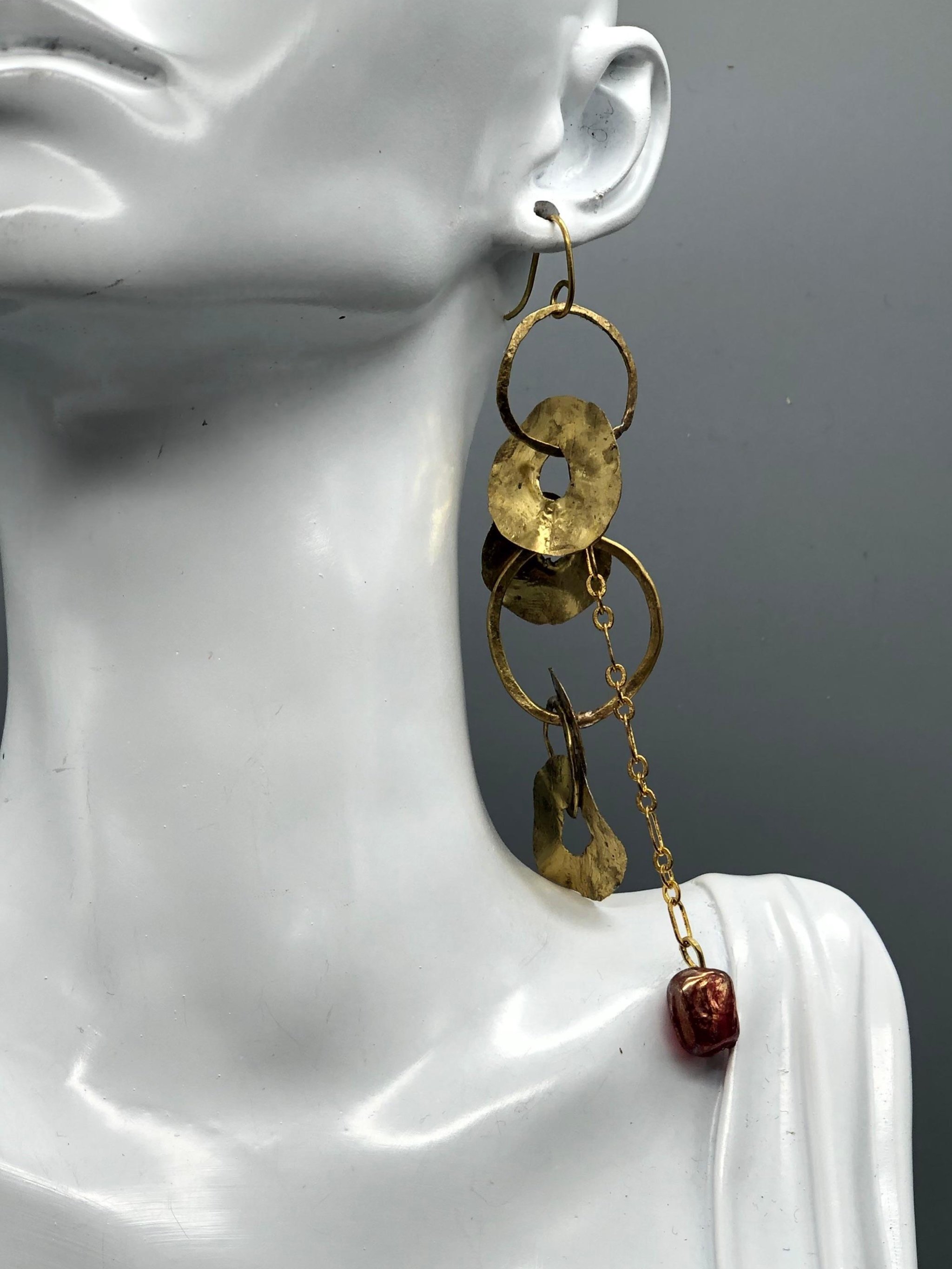 Mono orecchino Orbit Chain di Claudia Cuzzeri in ottone opaco con elementi circolari irregolari, catena e dettaglio in vetro di Murano