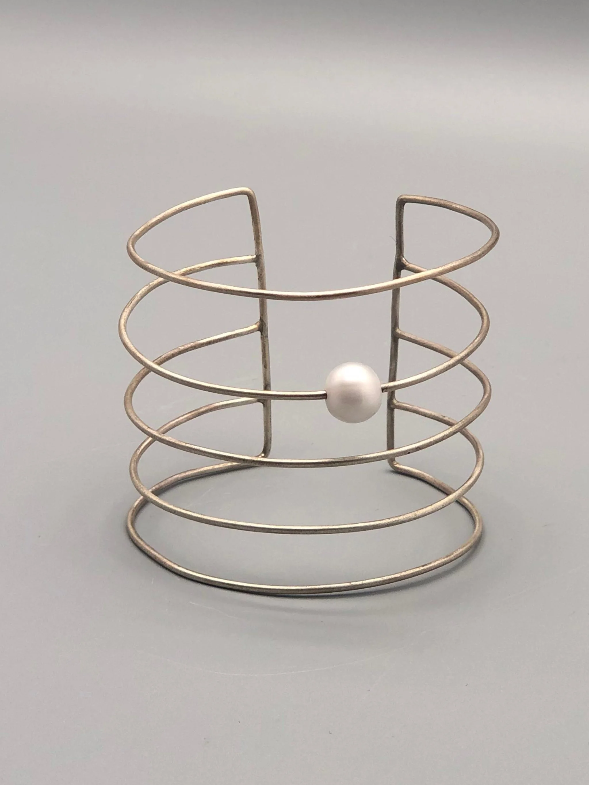 Bracciale Asmara in argento 925 con perla bianca, design scultoreo a linee aperte — Crepundia Gioielli — Crepundia Bologna, architectural silver cuff bracelet with pearl