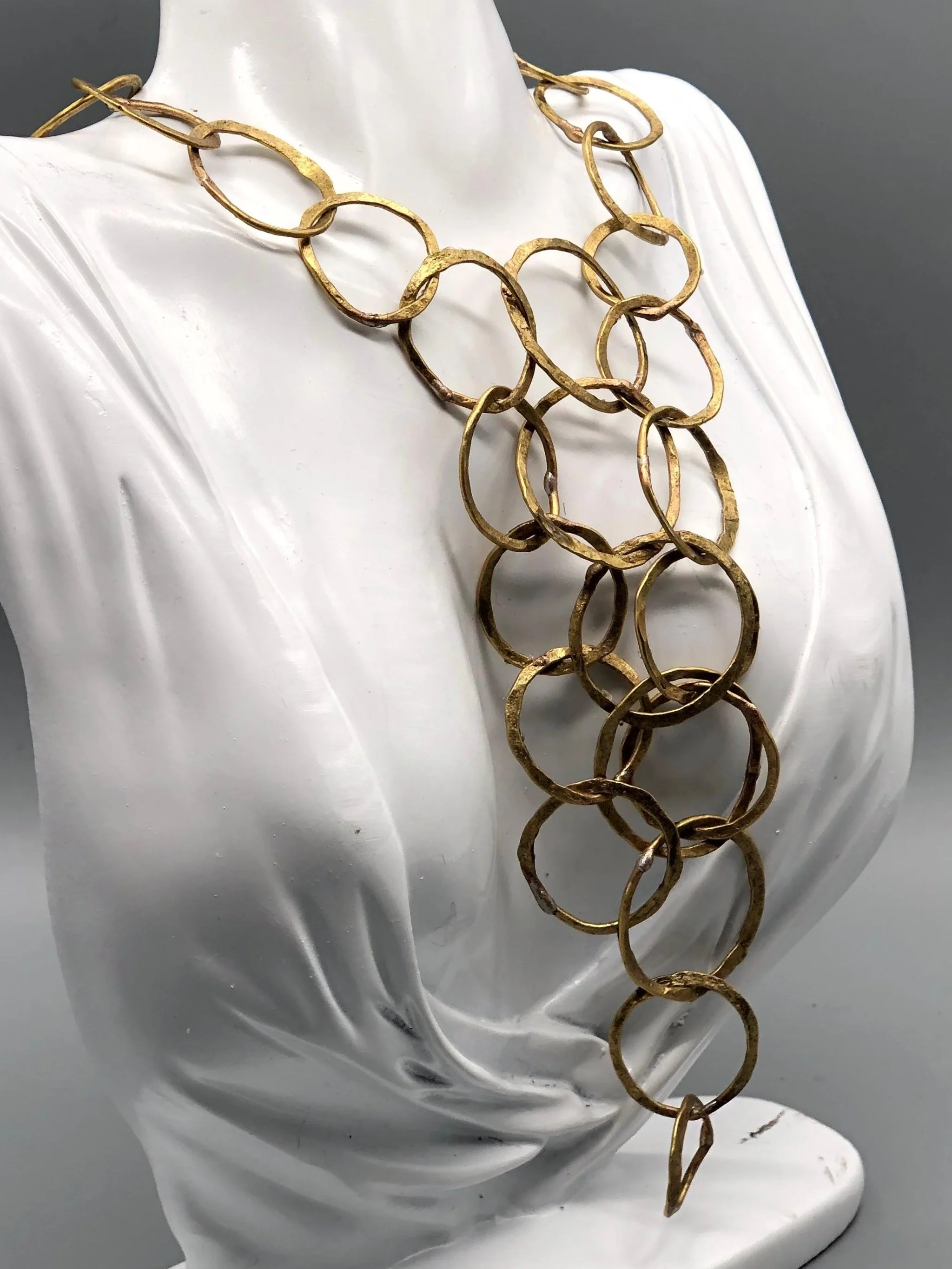 Collana Full Outline di Claudia Cuzzeri in ottone opaco, con maglie irregolari sovrapposte e struttura centrale ampia e articolata.