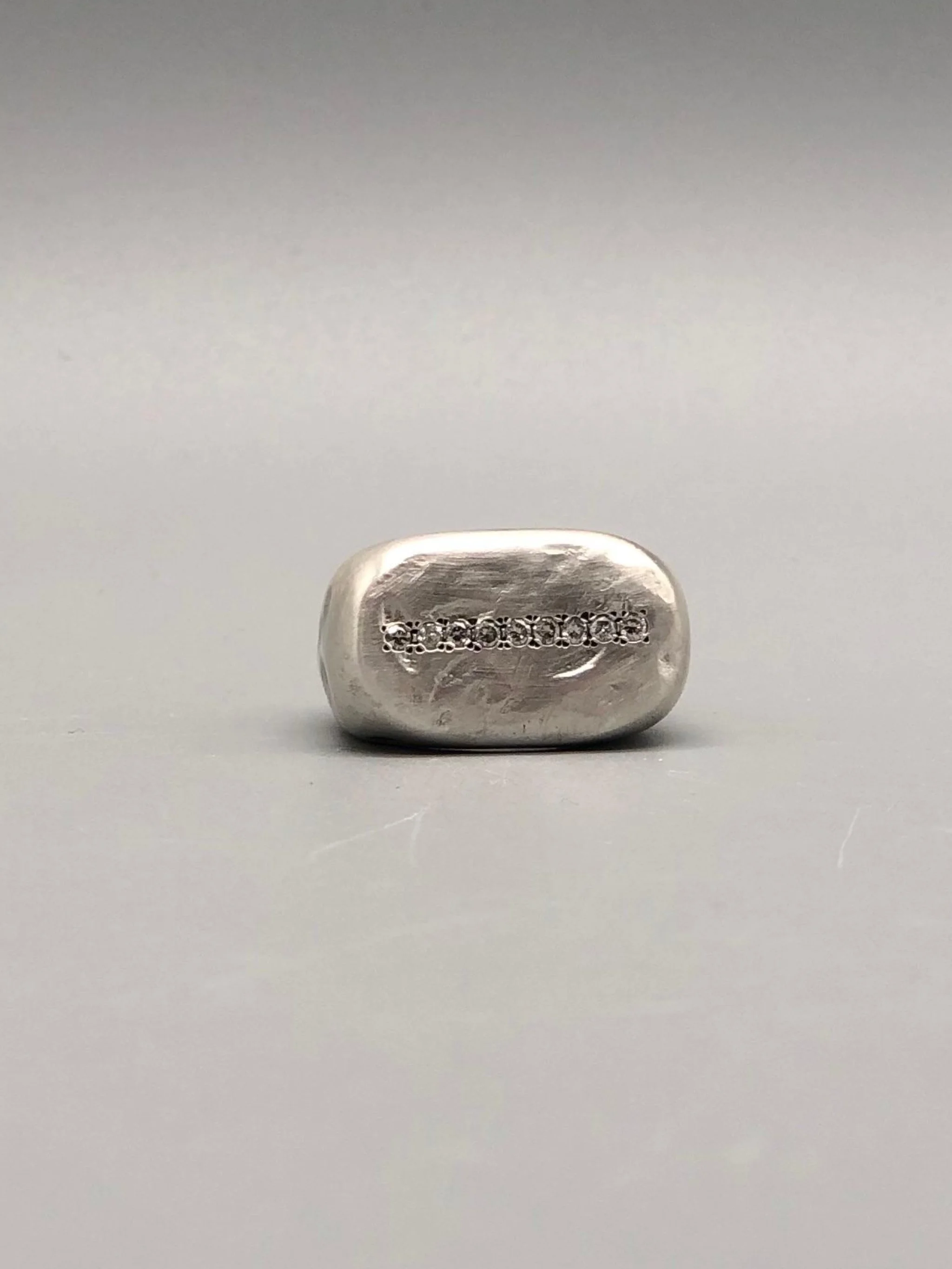 Crepundia Gioielli New Echo ring in matte silver with a line of diamonds.