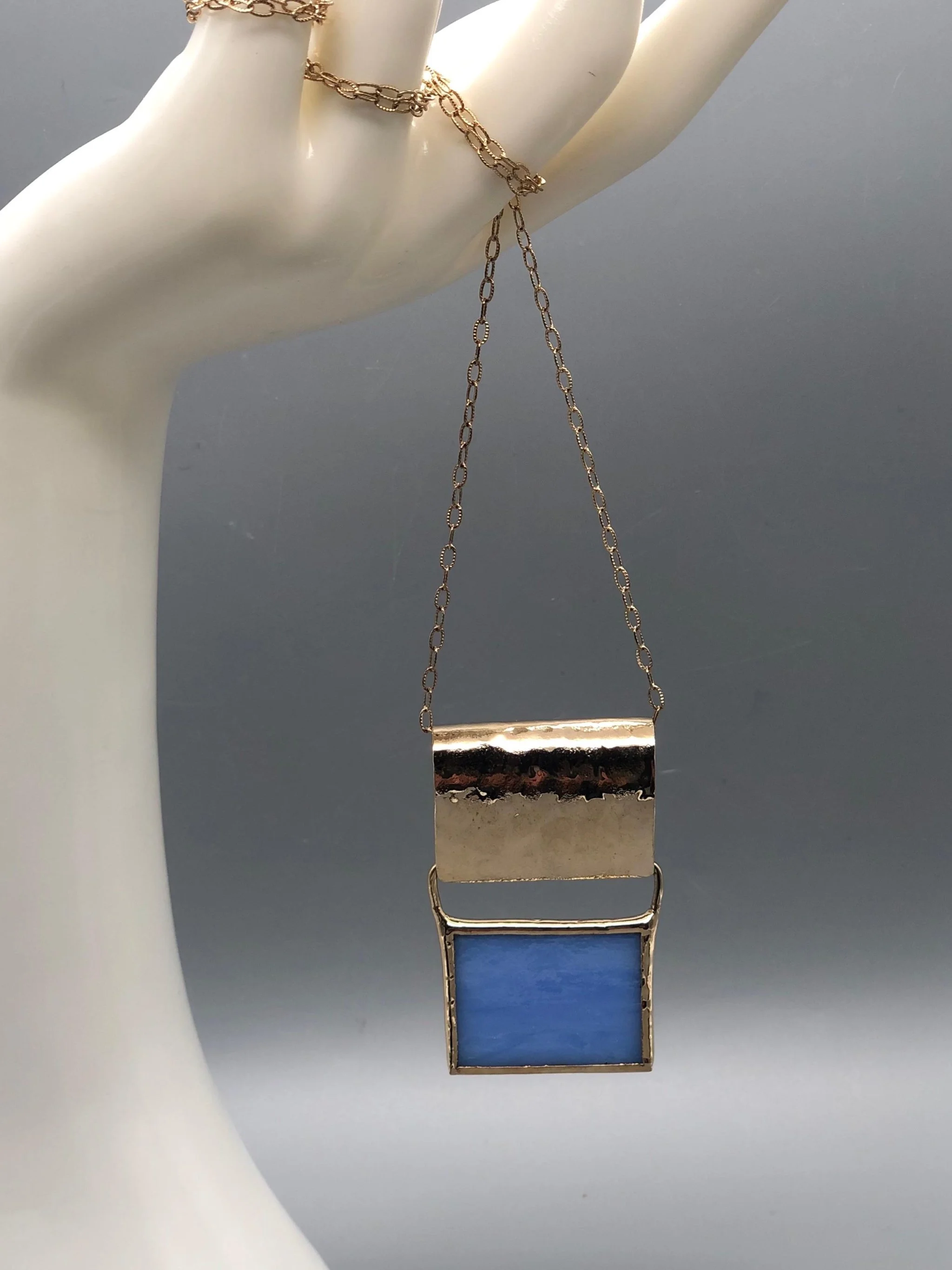 Collana ‘70 Azzurra di Anni Luce, ottone dorato e vetro di Murano. ‘70 Azzurra necklace by Anni Luce, gold-plated brass and Murano glass.