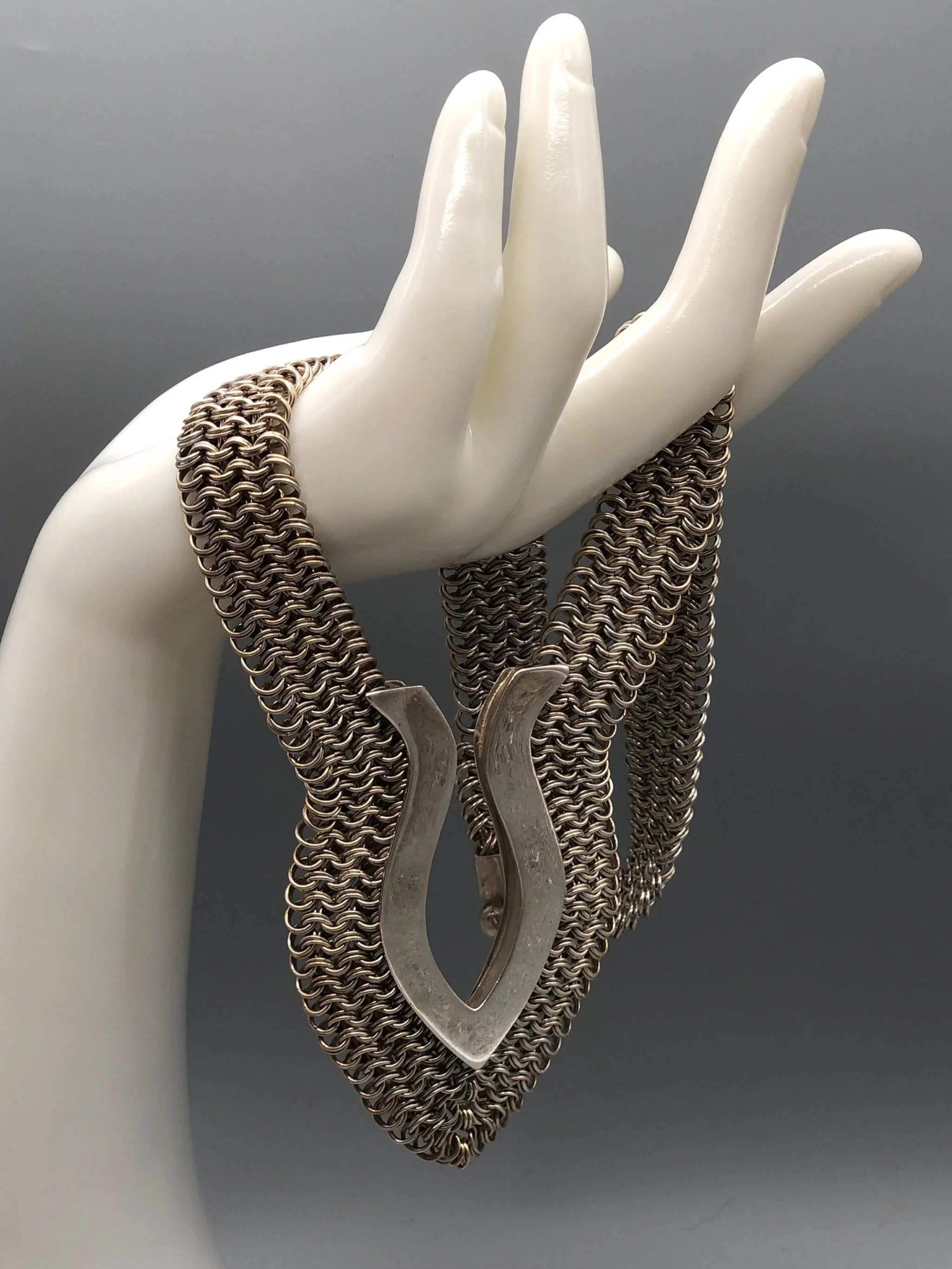 Piscis necklace by Ariadna Segafredo, crafted in woven metal mesh with a sculptural clasp for Crepundia Gioielli.