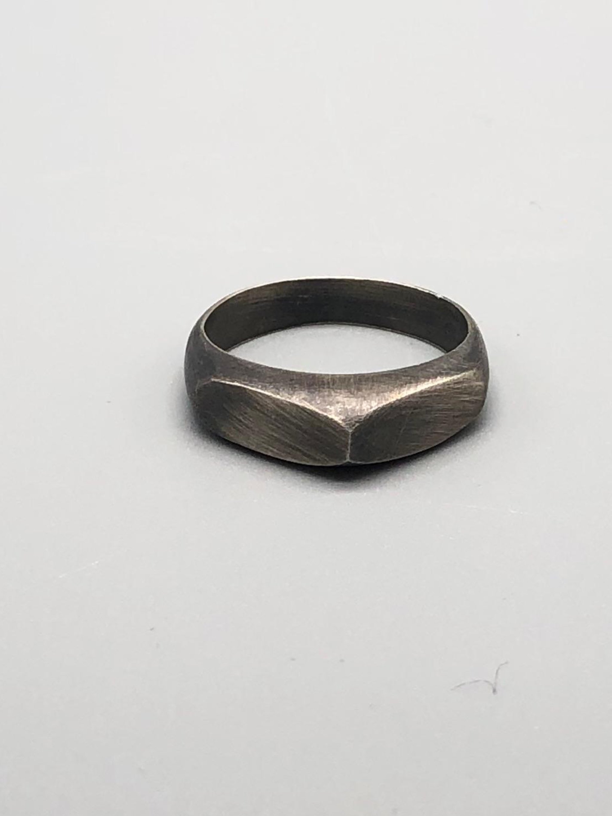 Tre anelli Cuspide di Crepundia Gioielli in argento, argento brunito e bronzo, sovrapposti in una composizione geometrica e scultorea.  Three Crepundia Cuspide rings in sterling silver, oxidized silve