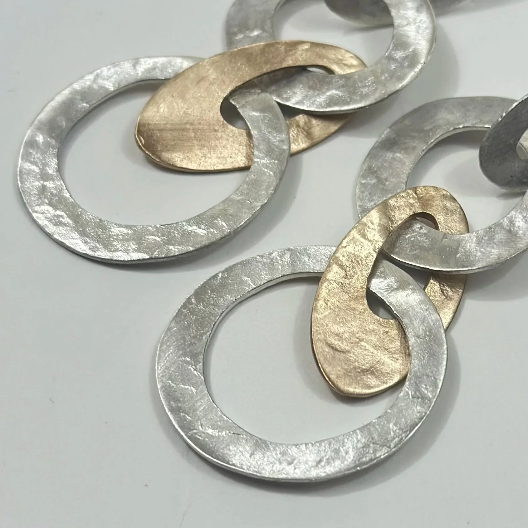 Orecchini pendenti in argento e bronzo con elementi a catena dal design moderno. Dettaglio – Crepundia Gioielli