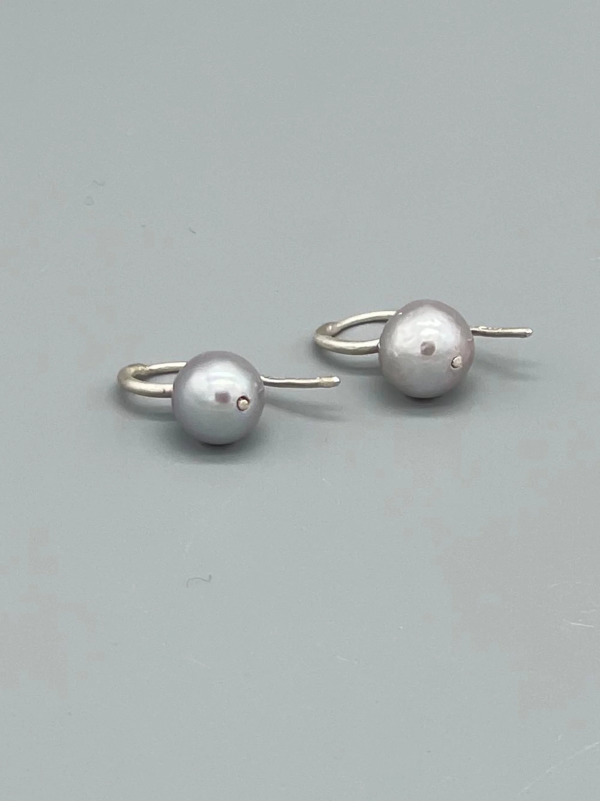 Perle grigie Crepundia in argento opaco, design contemporaneo.