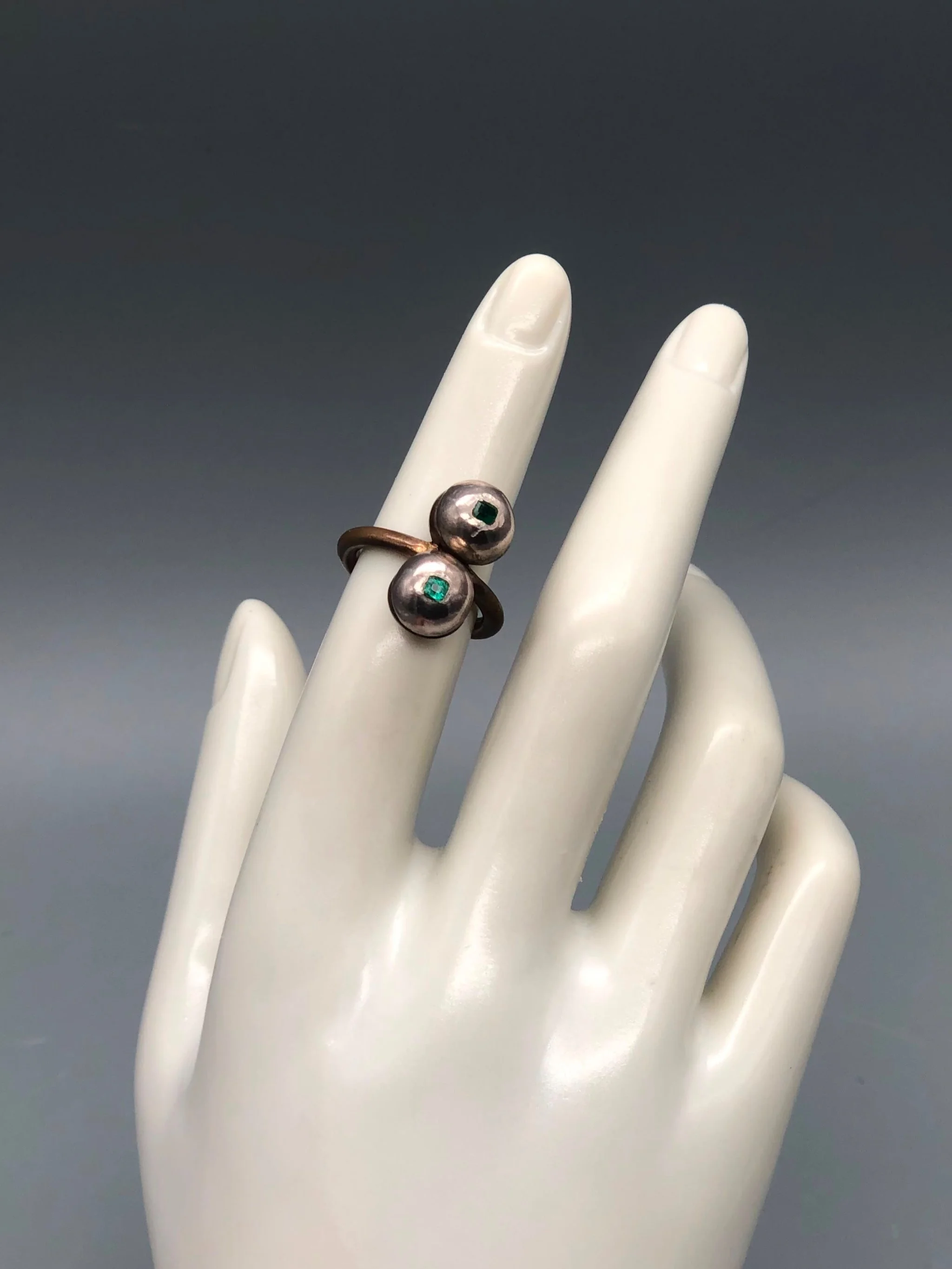 Raimondi ring in bronze and silver with two spherical elements and emeralds.