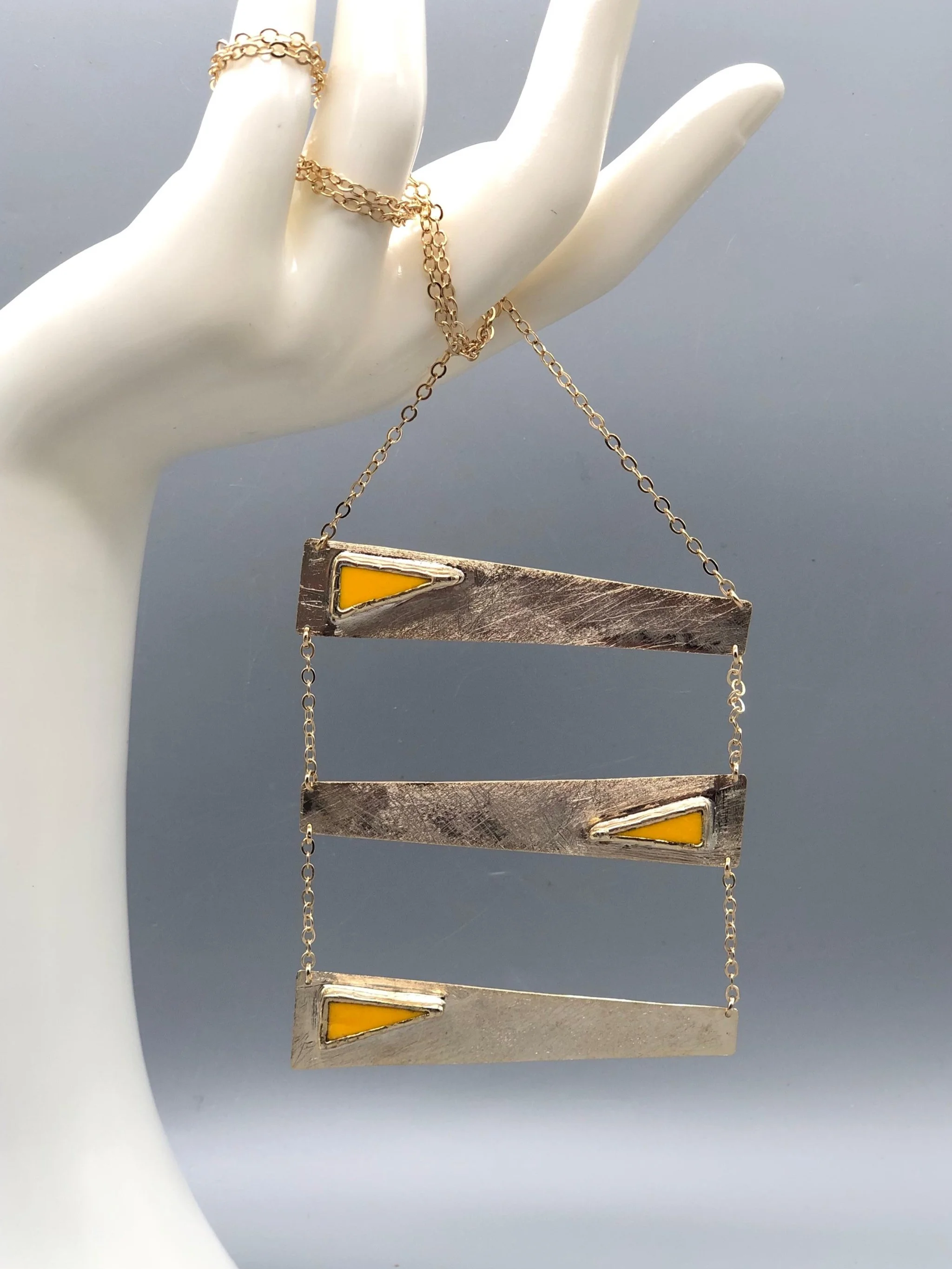 Collana Tris Gialla di Anni Luce, tre elementi geometrici in ottone dorato e vetro di Murano giallo