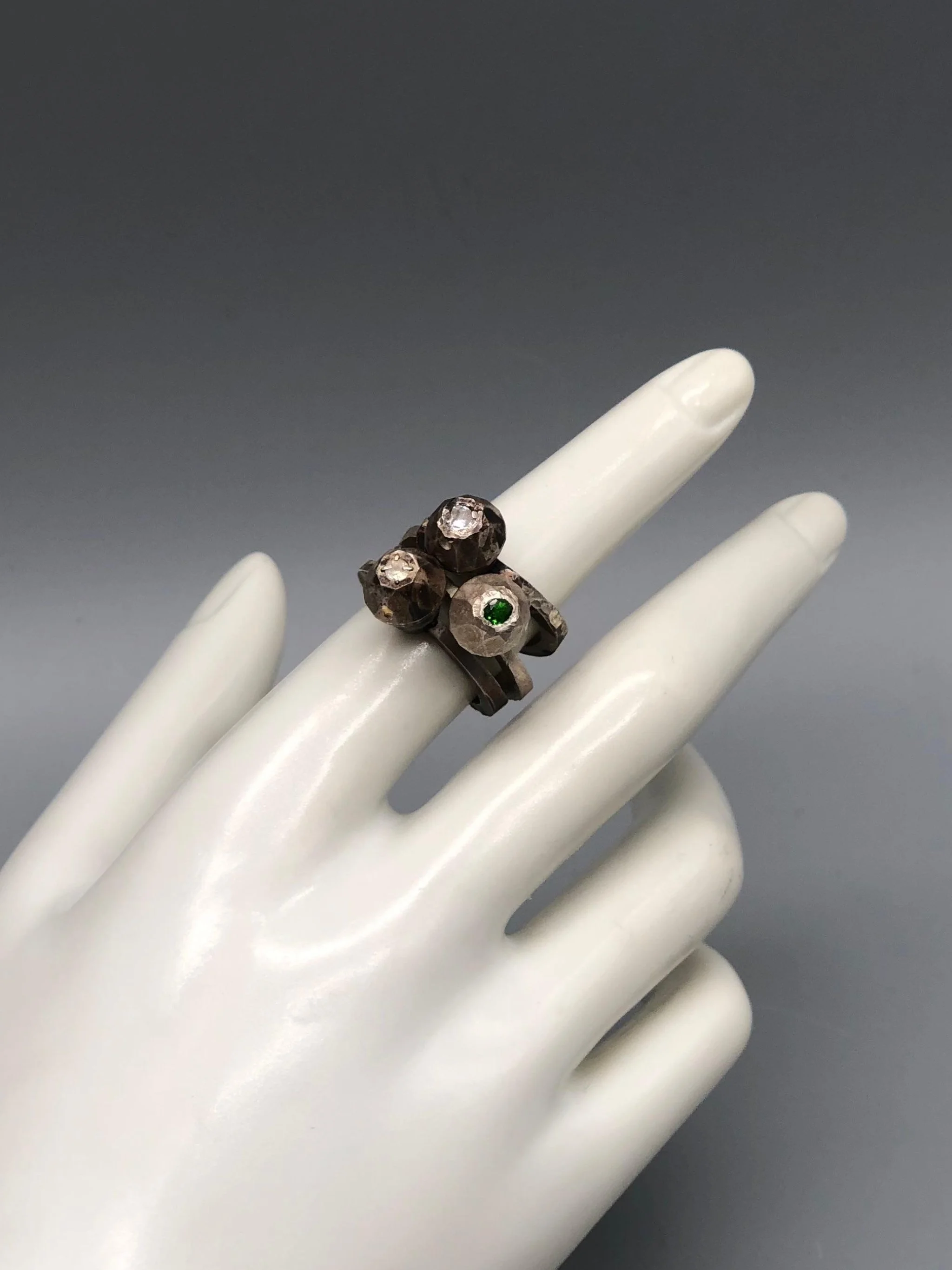 Contemporah Diamonds ring in oxidized 925 grey sterling silver with chromediopside, moonstone and Swarovski details. Contemporary sculptural ring photographed at Crepundia Gioielli Bologna.