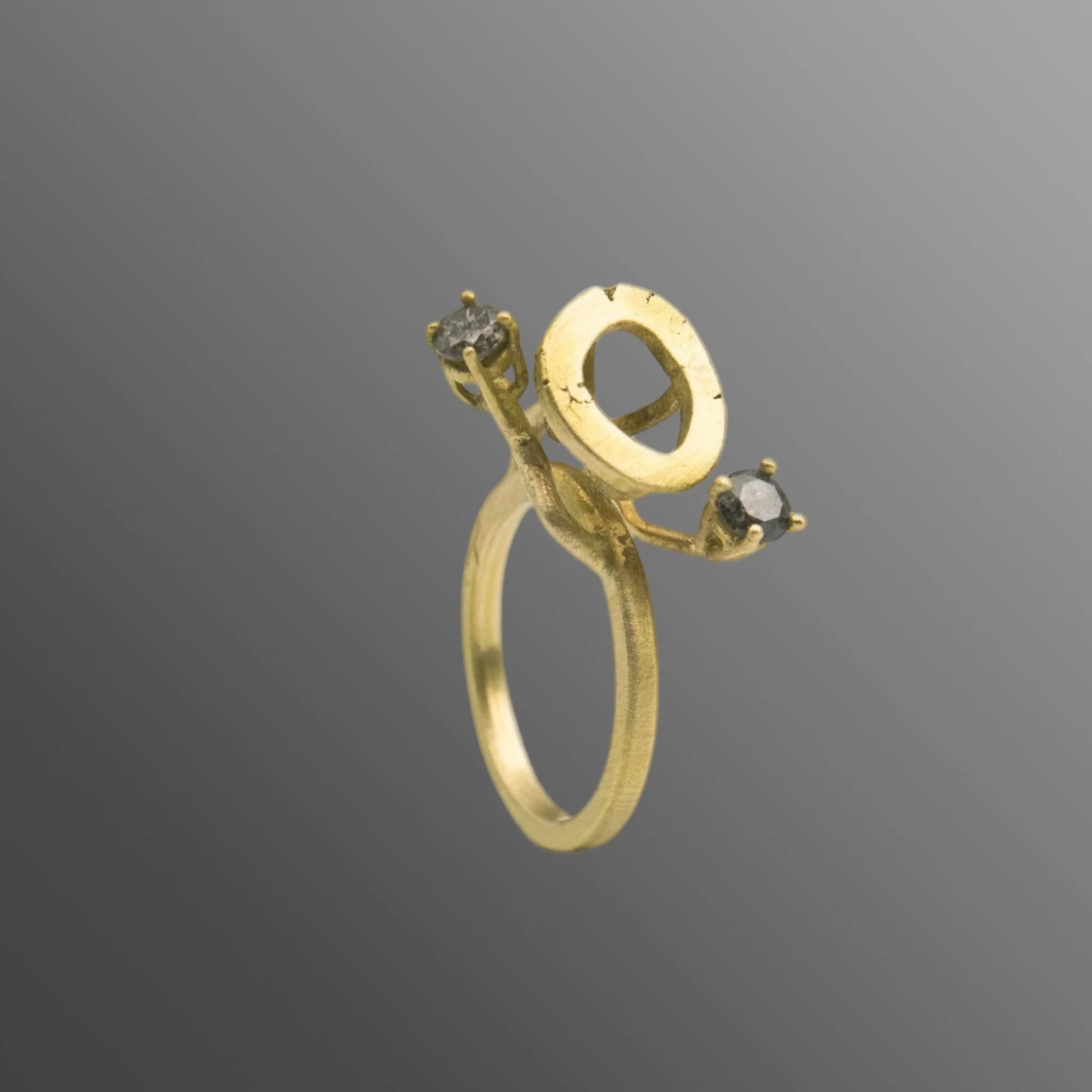 Anello in oro con due diamanti grigi, composizione aperta con elementi in equilibrio e tensione, struttura verticale e segno dinamico, Crepundia Gioielli — Crepundia Bologna — gold ring with two grey diamonds, open composition and dynamic vertical st