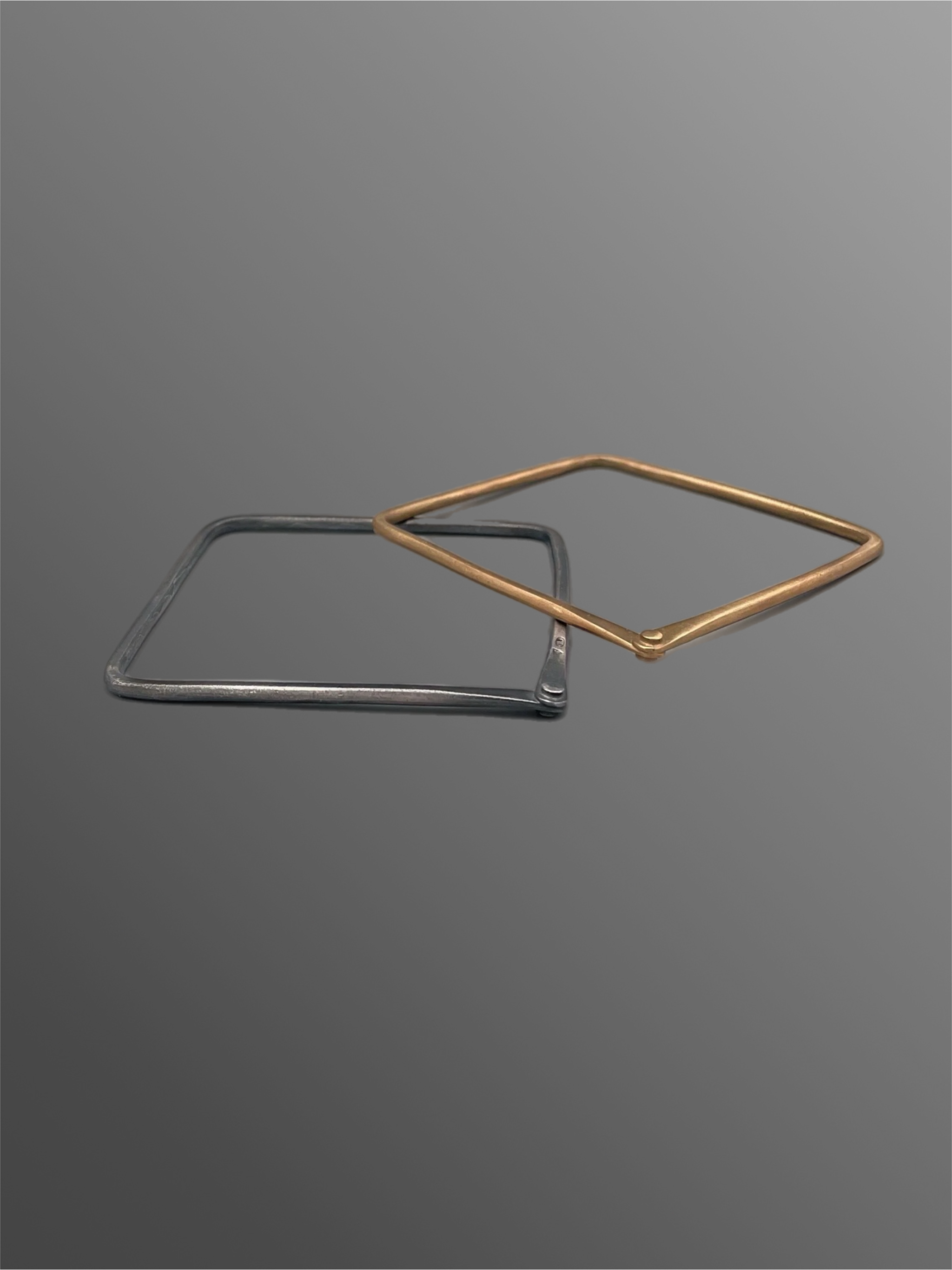 Geometric bangle by Crepundia in burnished silver and matte bronze worn on white mannequin hand — Crepundia Gioielli Crepundia Bologna