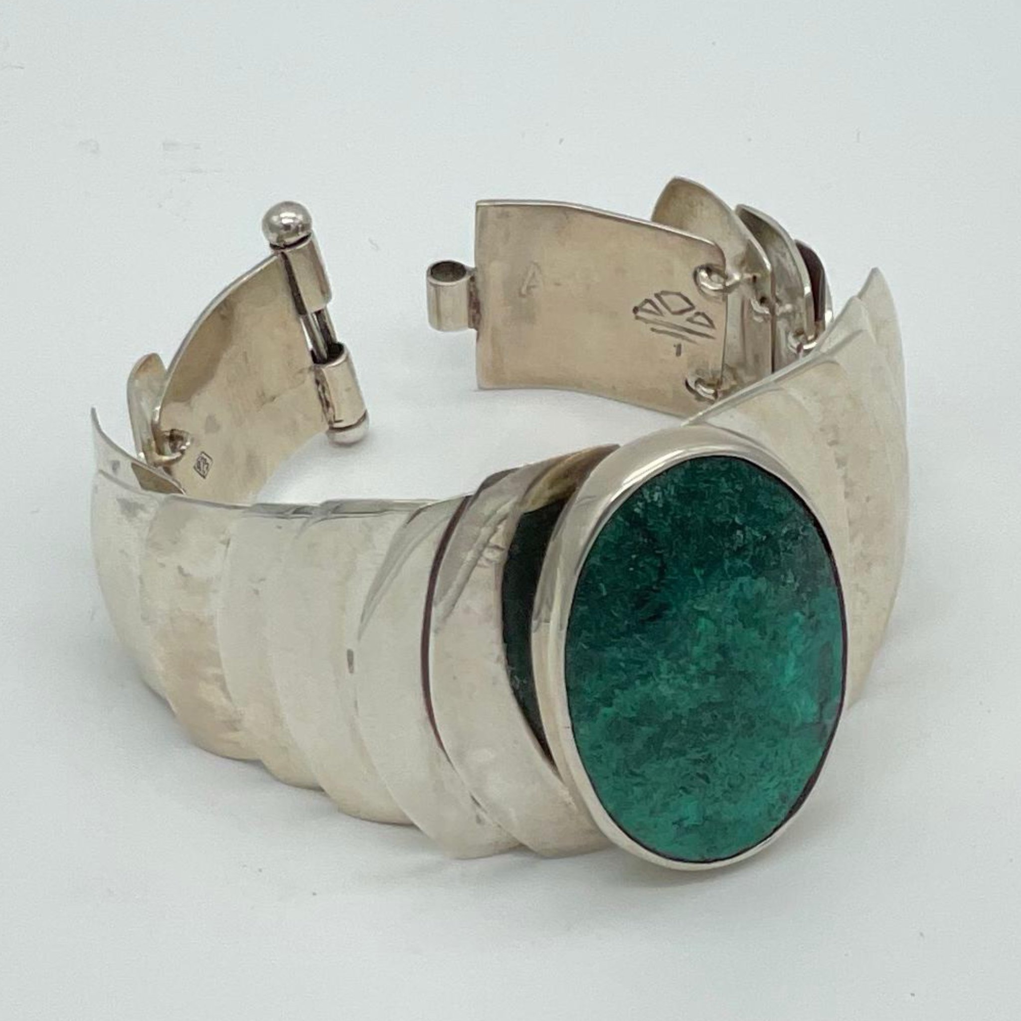 Bracciale in argento costruito per stratificazione, con un elemento centrale in crisocolla che definisce il punto focale.
La struttura si sviluppa per progressione, accompagnando la pietra in un equilibrio tra materia e ritmo.
Silver bracelet built t