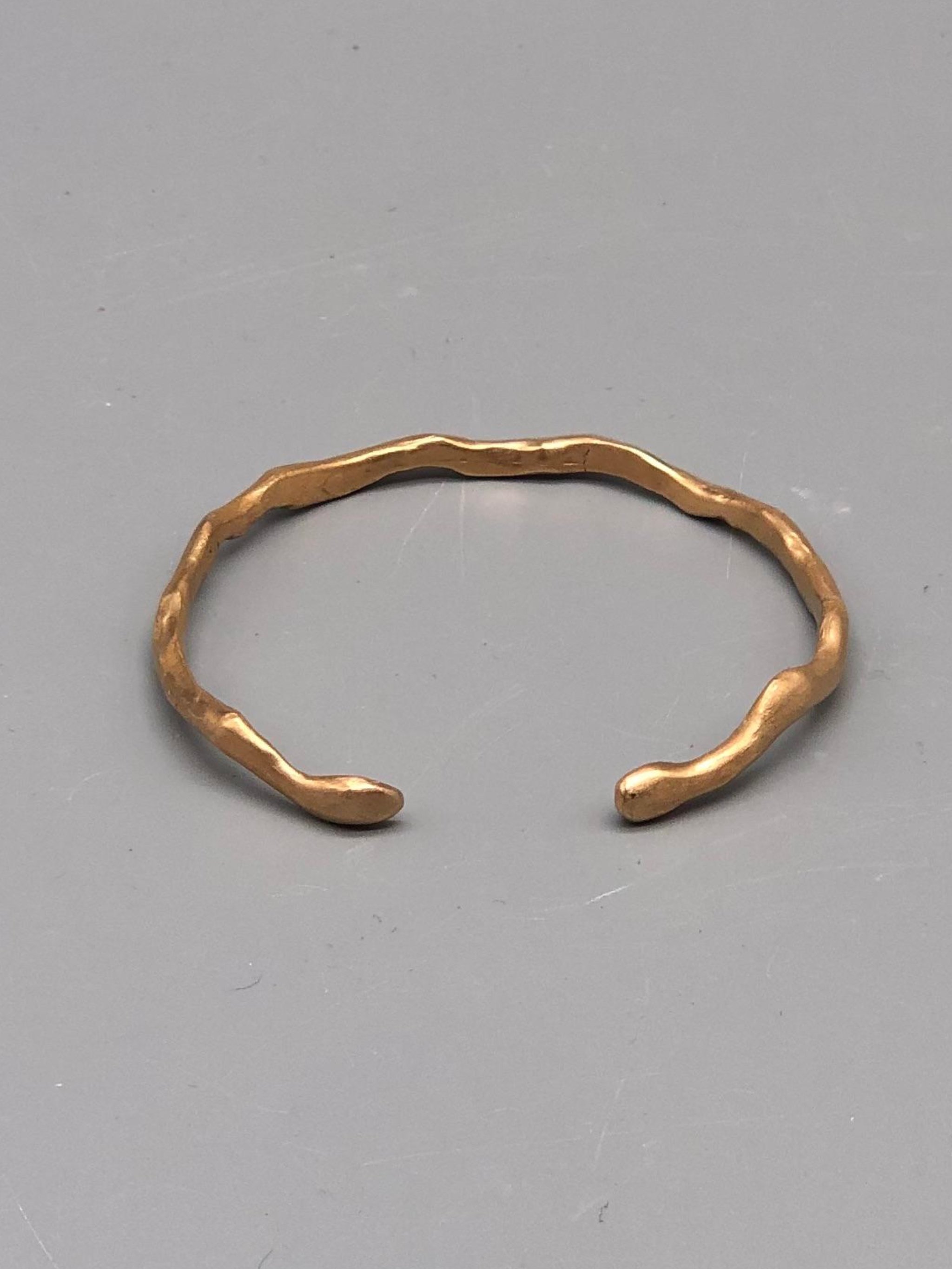 Handmade slender bronze cuff bracelet with organic sculptural shape by Floret Gioielli.