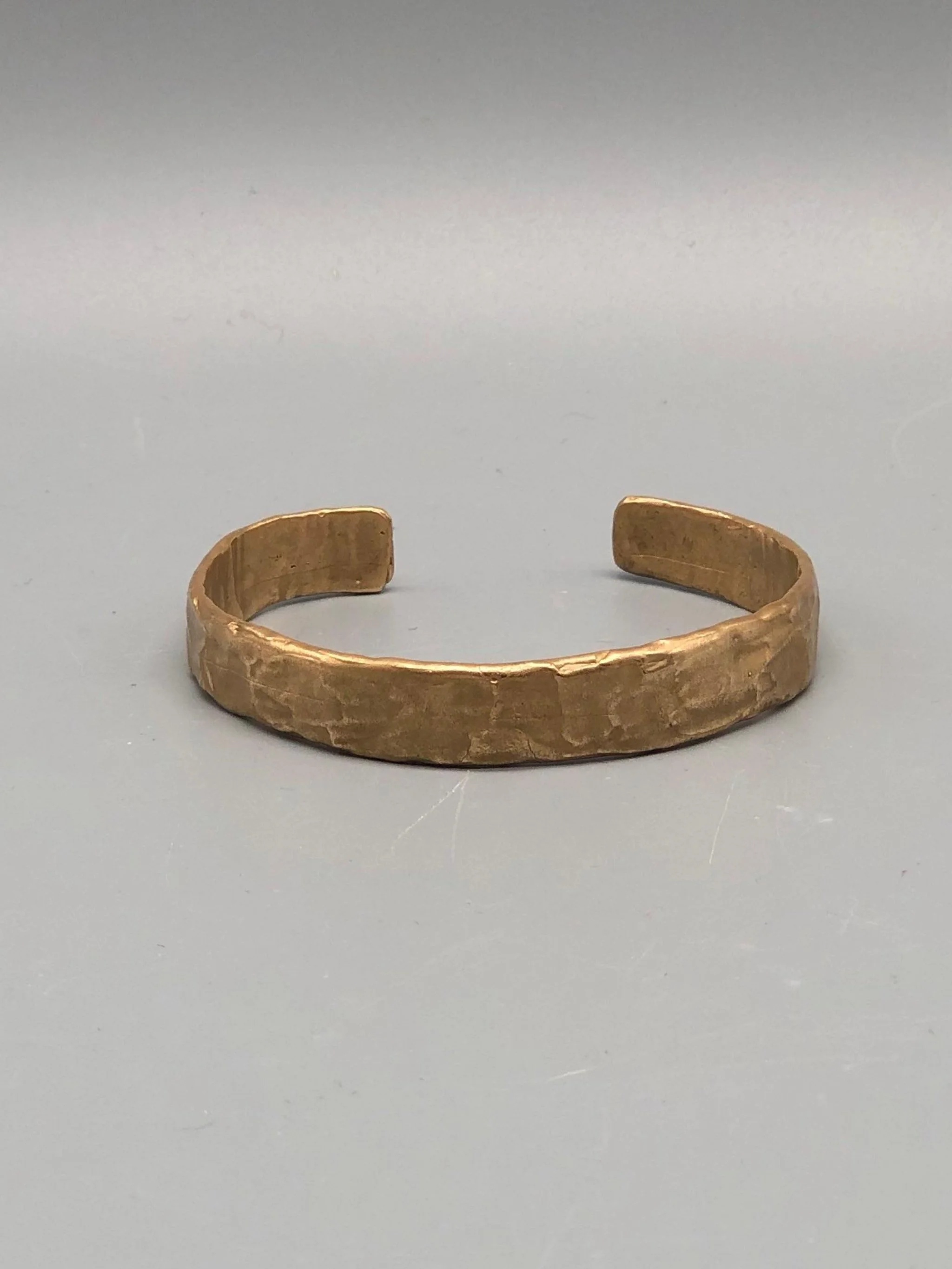 Handmade bronze cuff bracelet with textured sculptural surface by Floret Gioielli