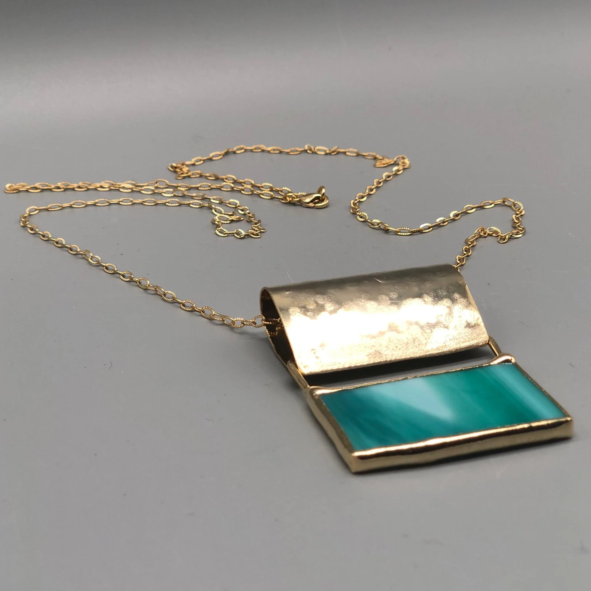 Anni Luce necklace in gold-toned metal with green glass insert, contemporary jewelry Crepundia Gioielli Bologna
Collana Anni Luce in metallo dorato con inserto in vetro verde, gioielli contemporanei Crepundia Gioielli Bologna