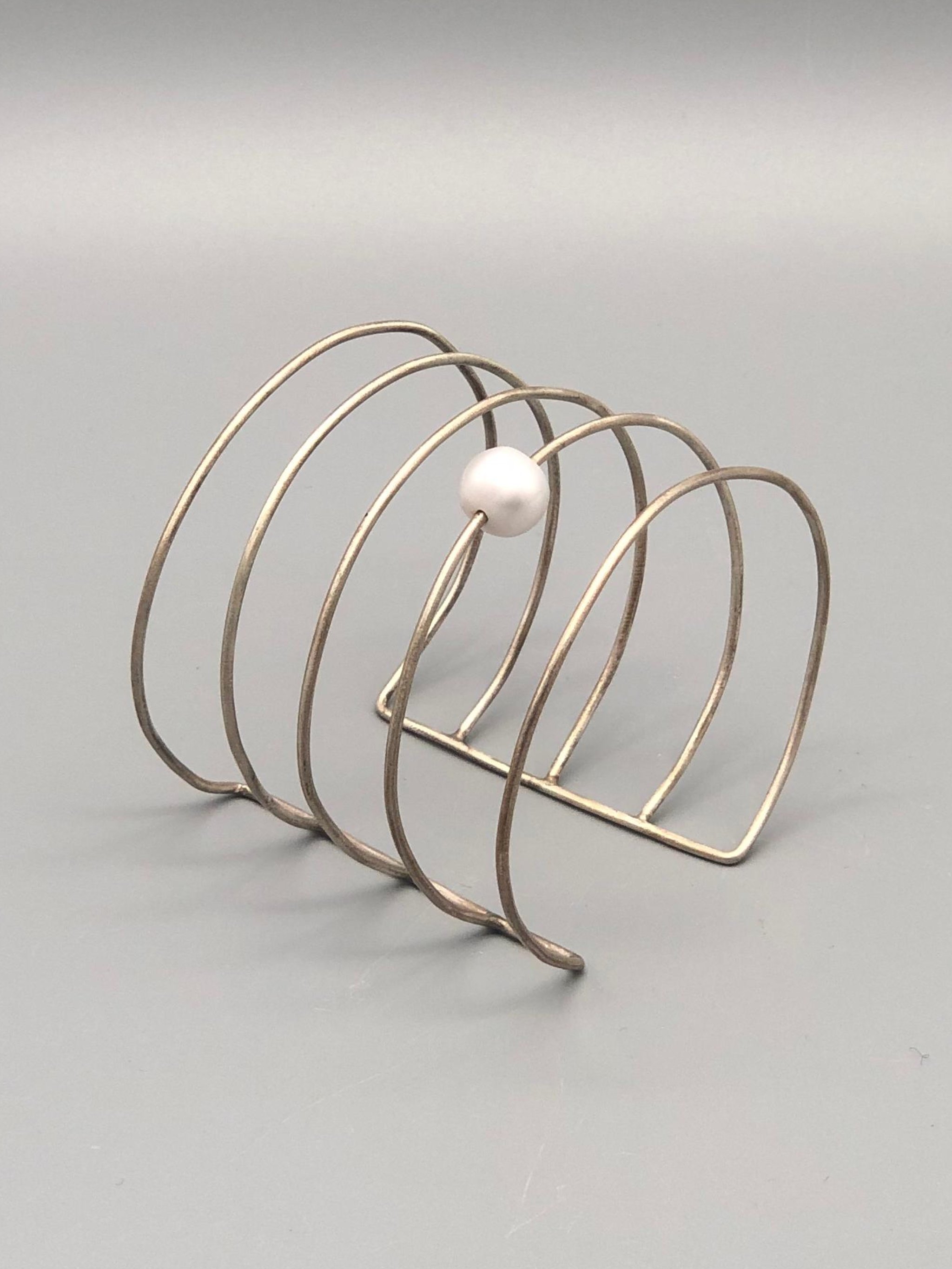 Bracciale Asmara in argento 925 con perla bianca, design scultoreo a linee aperte — Crepundia Gioielli — Crepundia Bologna, architectural silver cuff bracelet with pearl