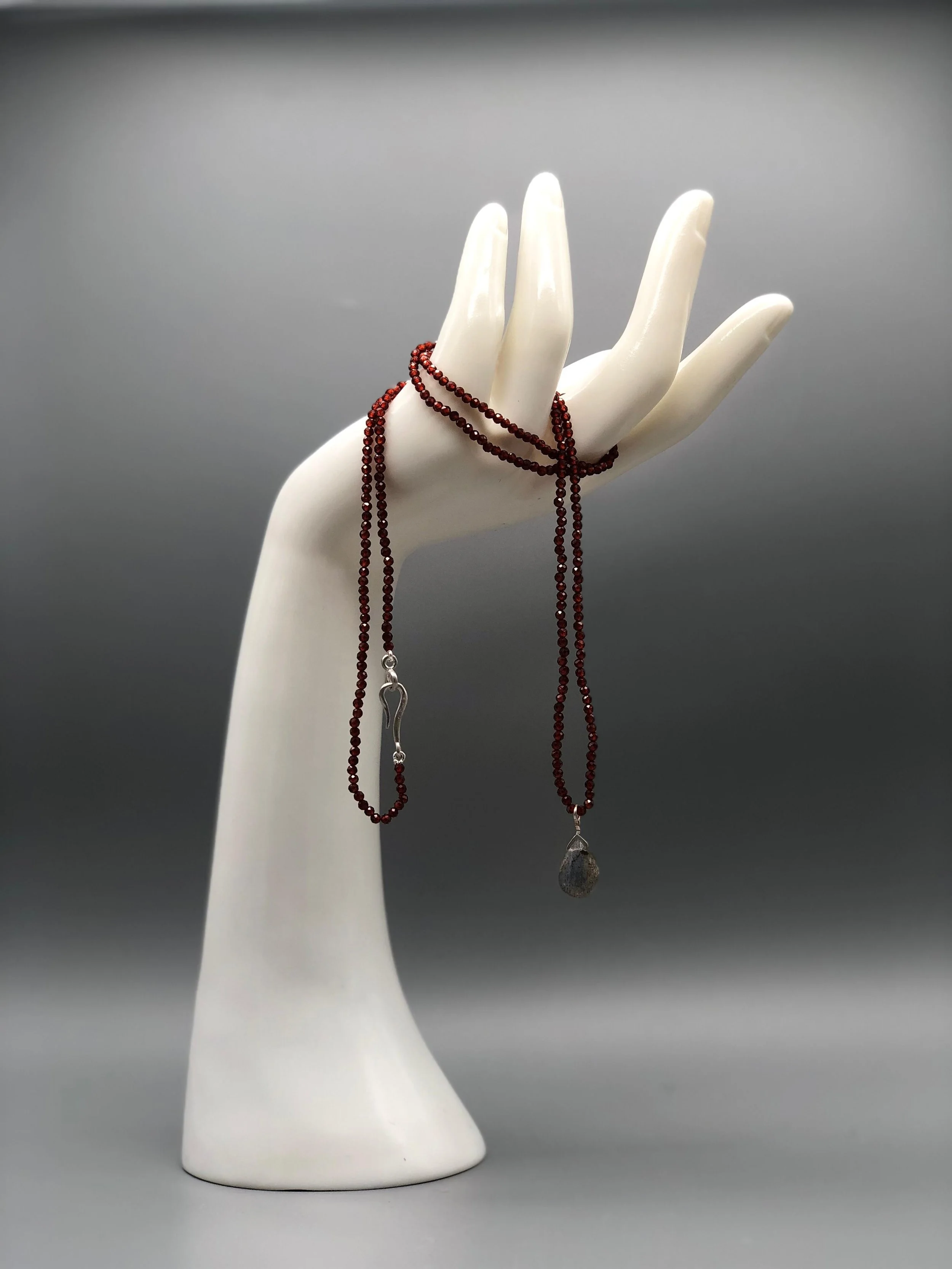 Collana Still Drops in granato rosso con goccia di labradorite, composizione lineare e sospesa design contemporaneo Crepundia Gioielli — Crepundia Bologna /
Still Drops necklace in red garnet with labradorite drop, linear and suspended composition co