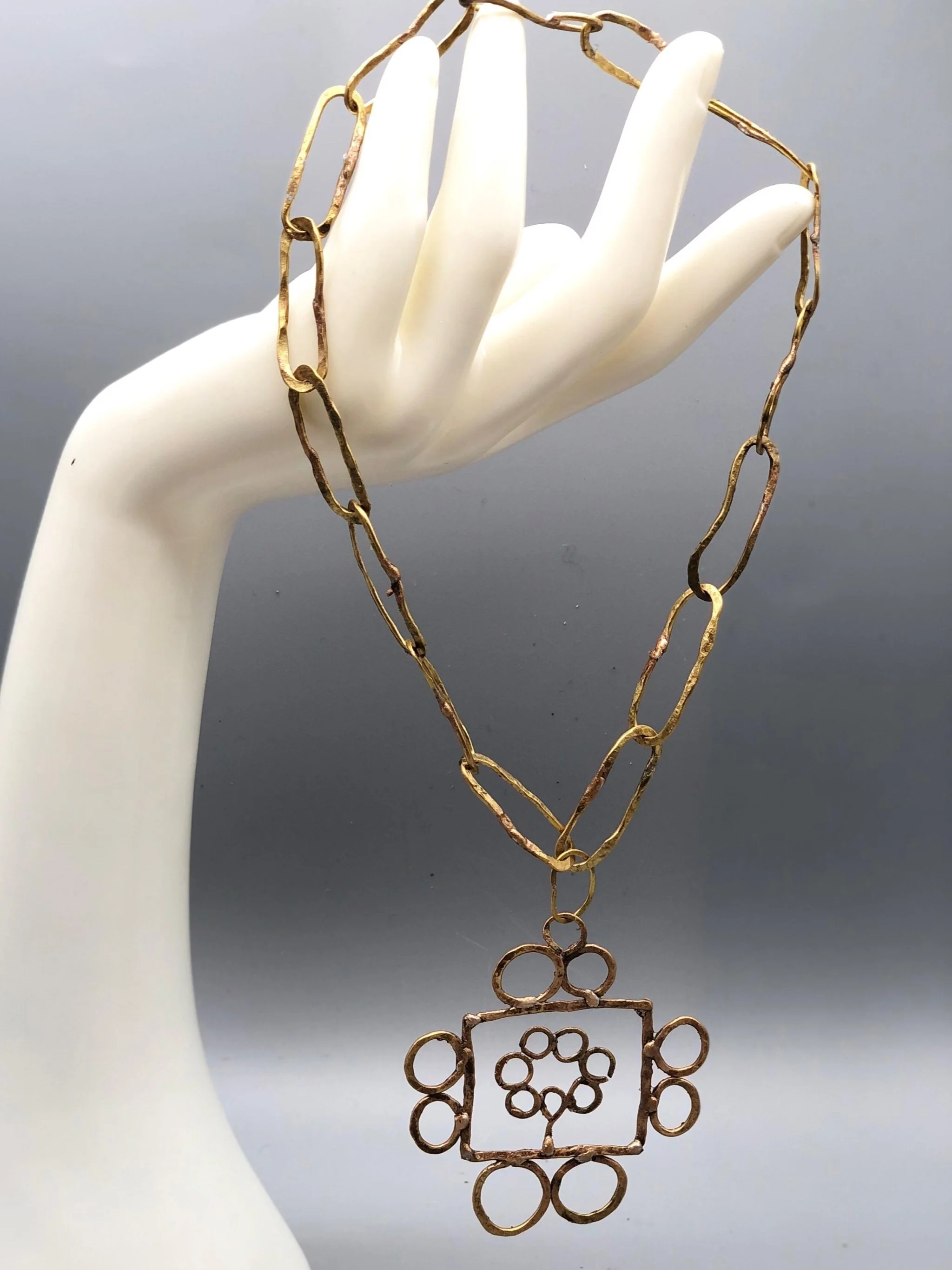 Collana Tree Frame di Claudia Cuzzeri in ottone opaco con maglie irregolari e pendente geometrico.