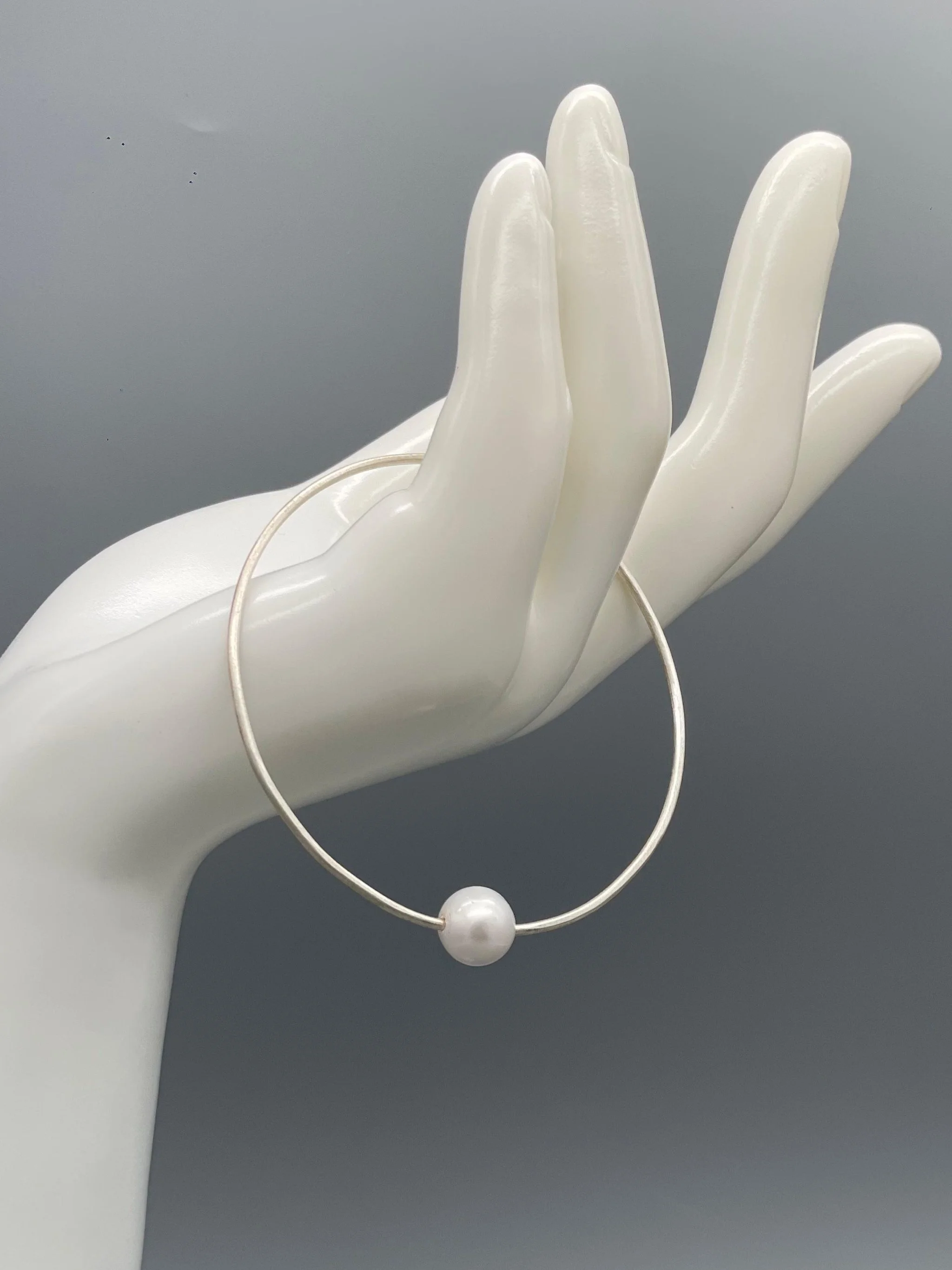 Bracciale Assuan Crepundia in argento con perla, design contemporaneo.