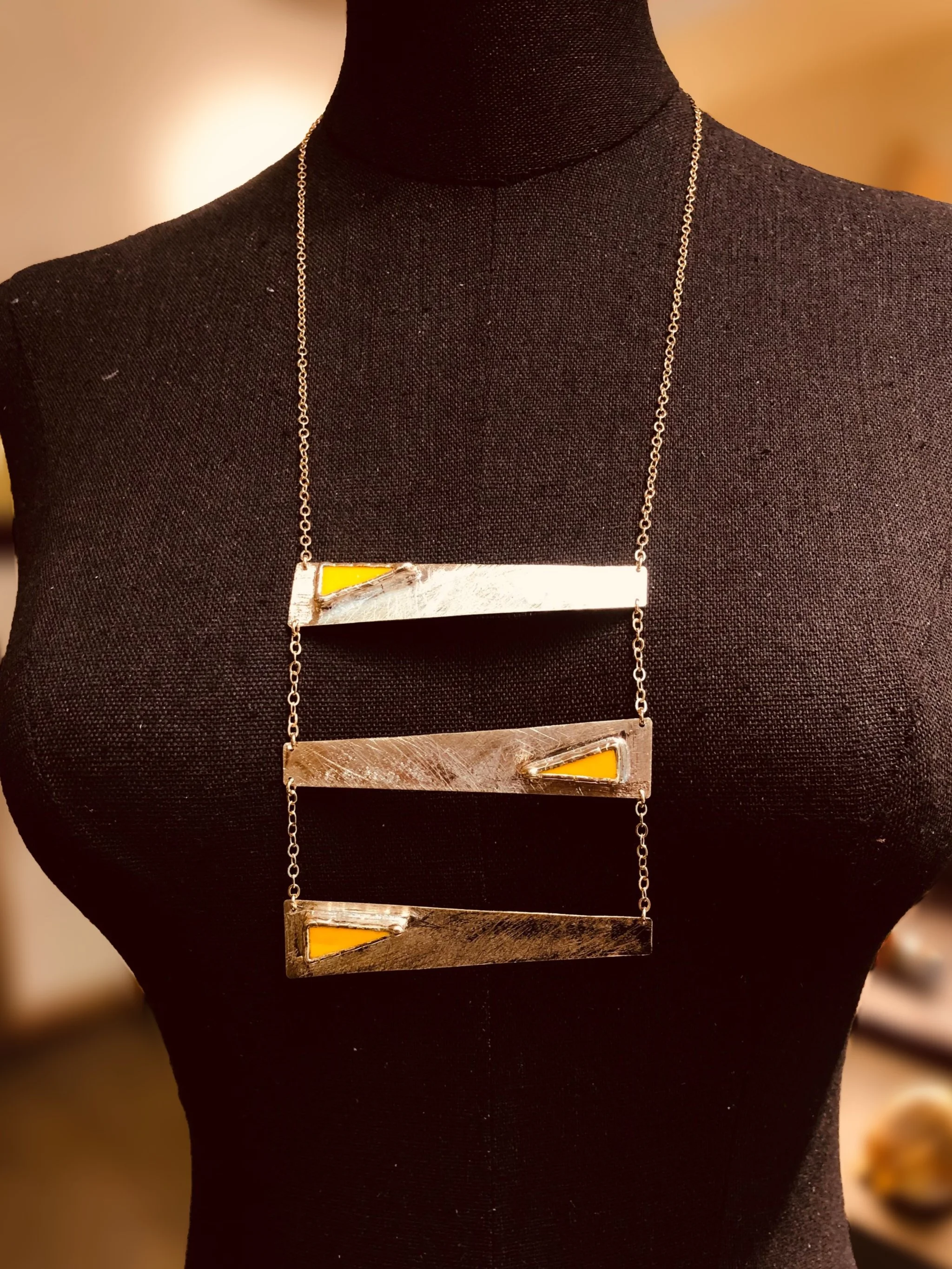 Collana Tris Gialla di Anni Luce, tre elementi geometrici in ottone dorato e vetro di Murano giallo