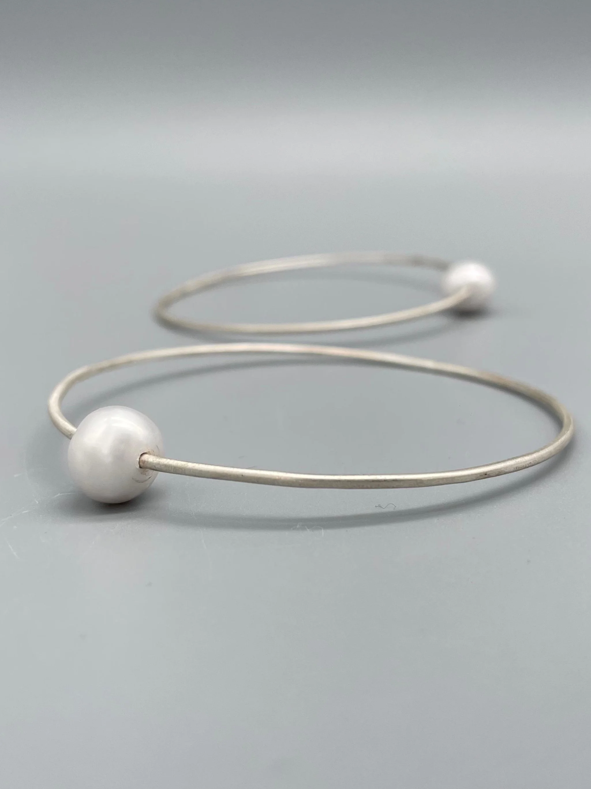 Bracciale Assuan Crepundia in argento con perla, design contemporaneo.