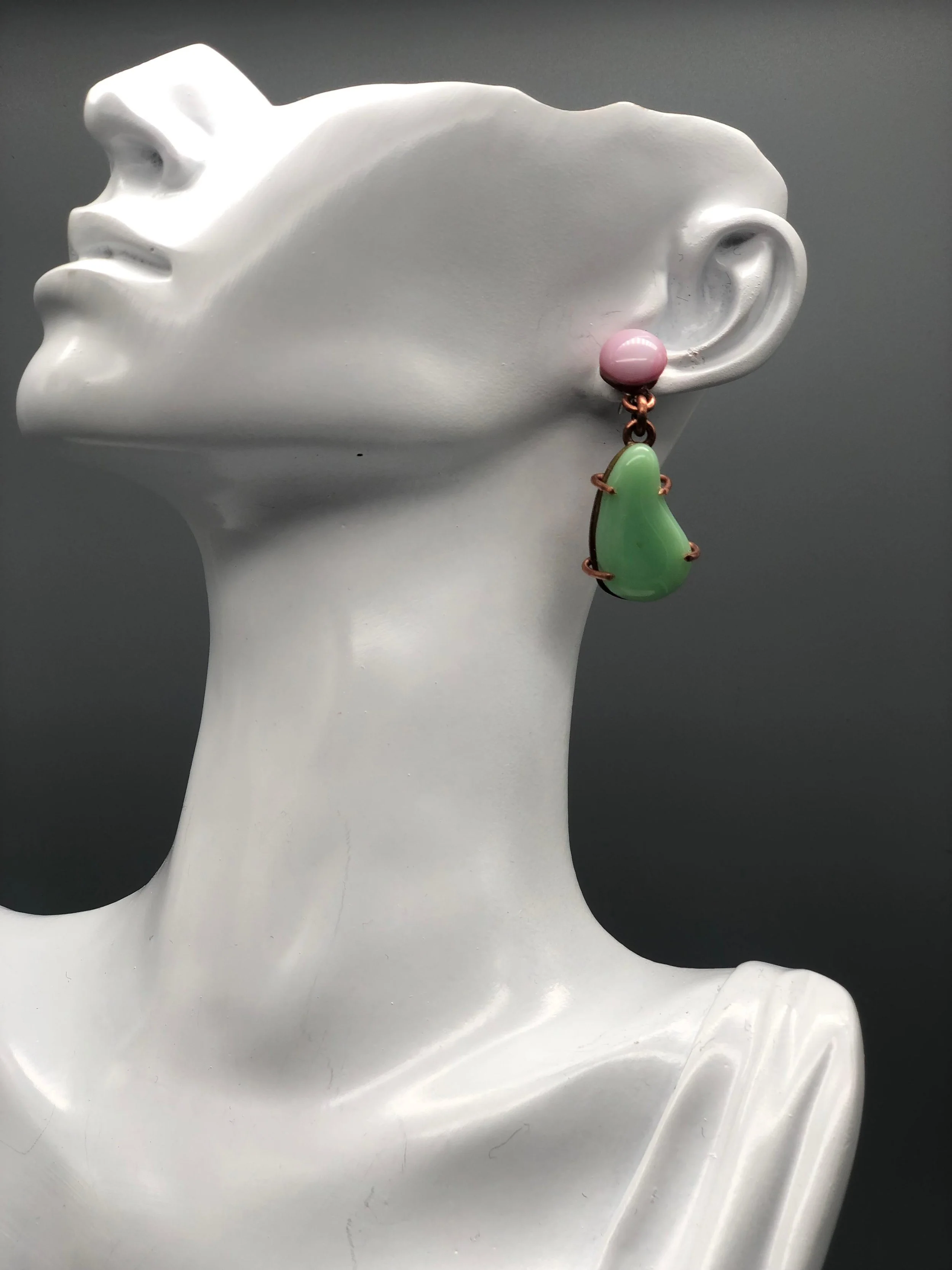Manumara Arte Design — asymmetrical earrings in fused glass with green and pink tones, lightweight sculptural design available at Crepundia Gioielli Bologna.
