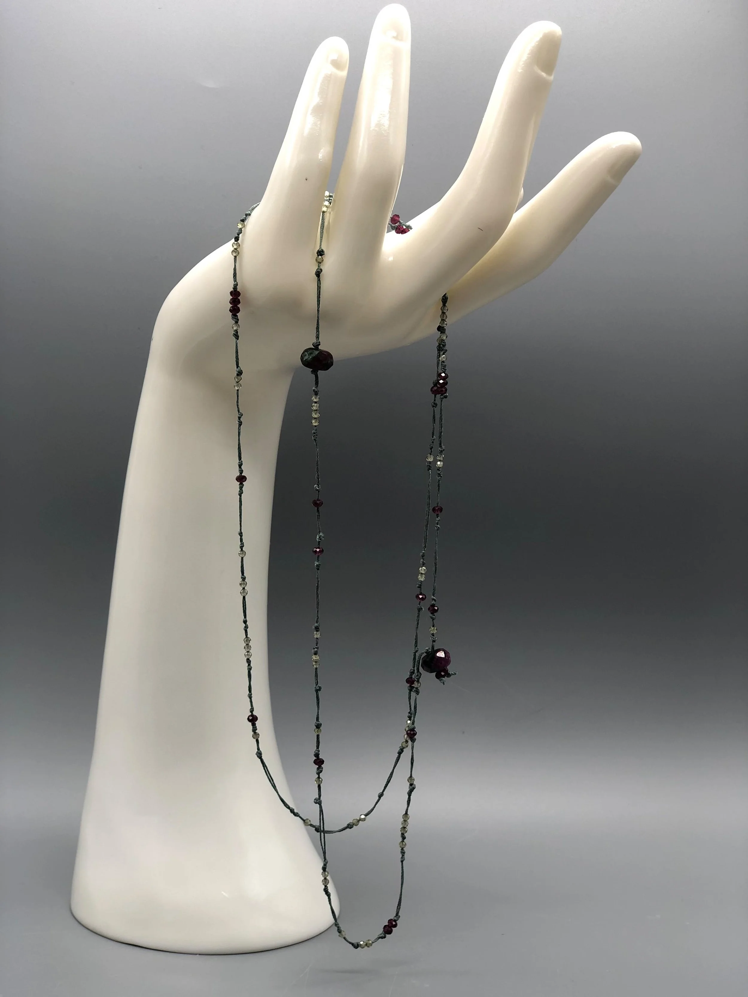 Collana Chromatic in zirconi colorati e diaspro sanguigno con filo di cotone verde salvia, pezzo unico Crepundia Gioielli.