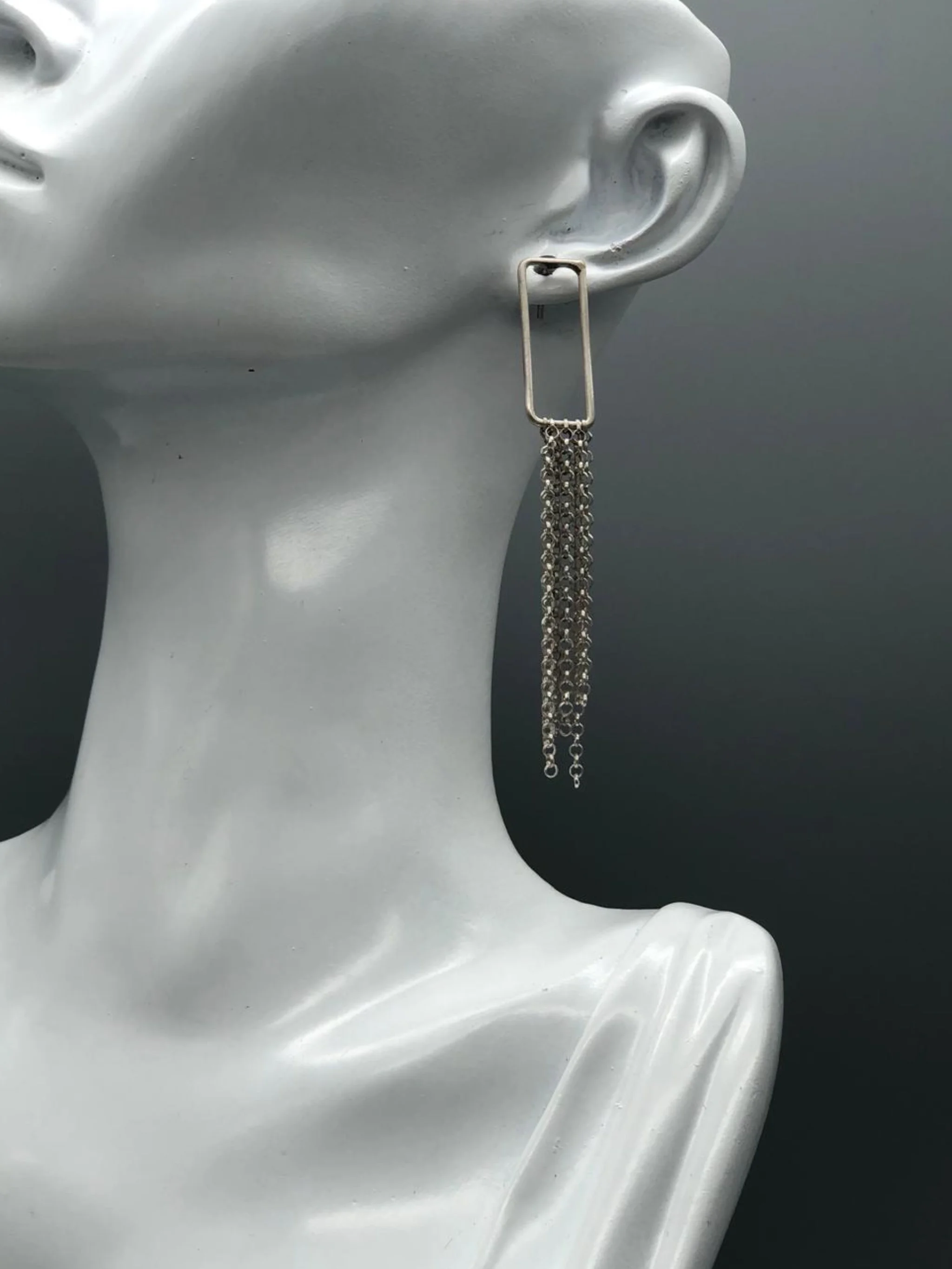 Orecchini Cascade Frame in argento 925 con struttura rettangolare aperta e cascata di sottili catene.