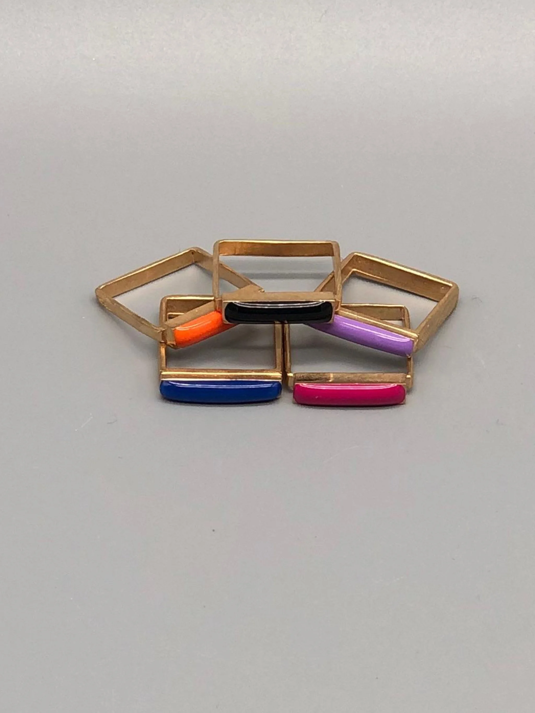 Slim enamel rings in bronze with gold finish, available in black, orange, pink, cornflower blue and purple enamel, Crepundia Gioielli Bologna.