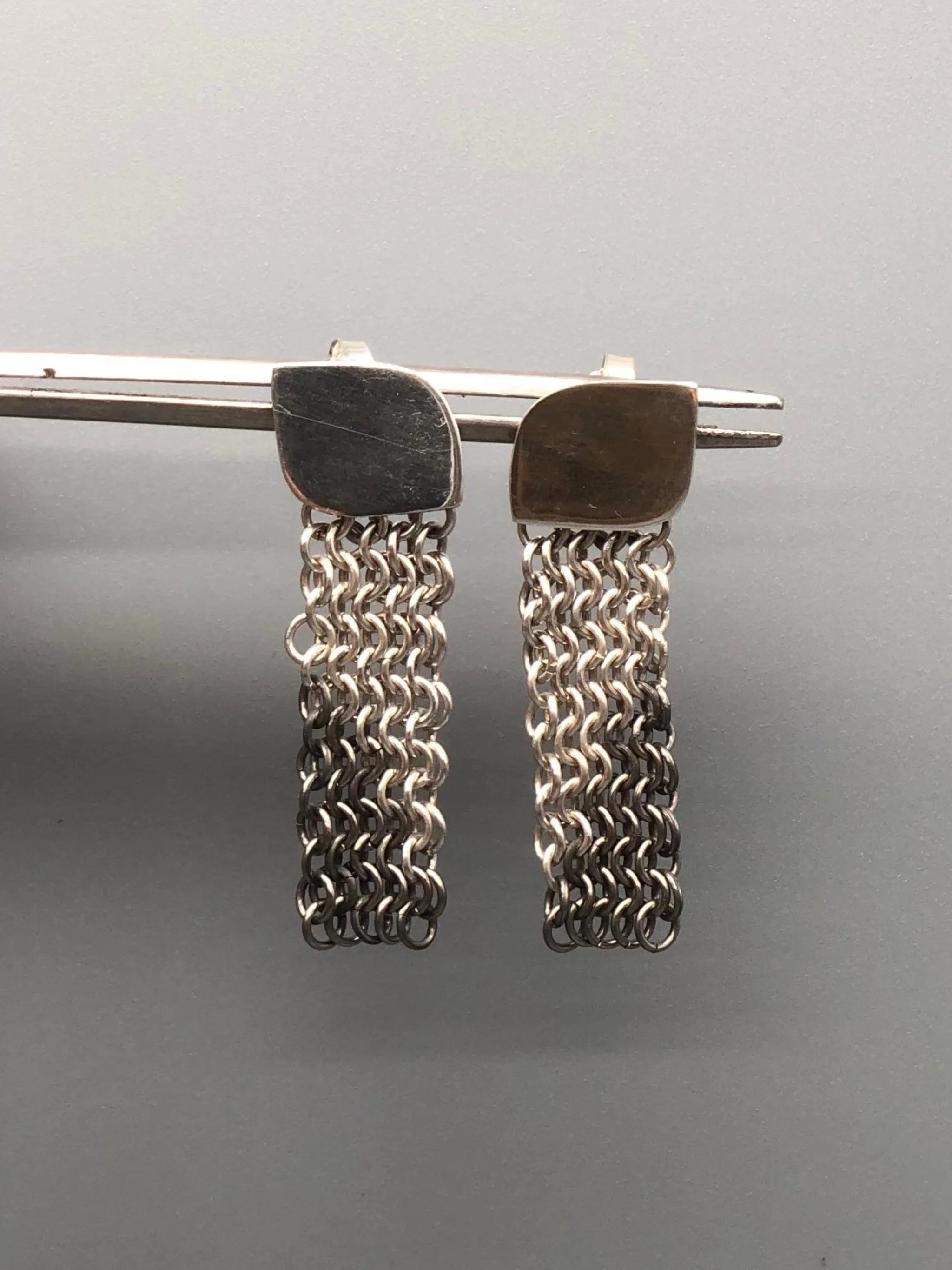 Sterling silver and titanium mesh earrings by Ariadna Segafredo for Crepundia Gioielli, featuring handcrafted woven titanium links and a minimalist silver top.