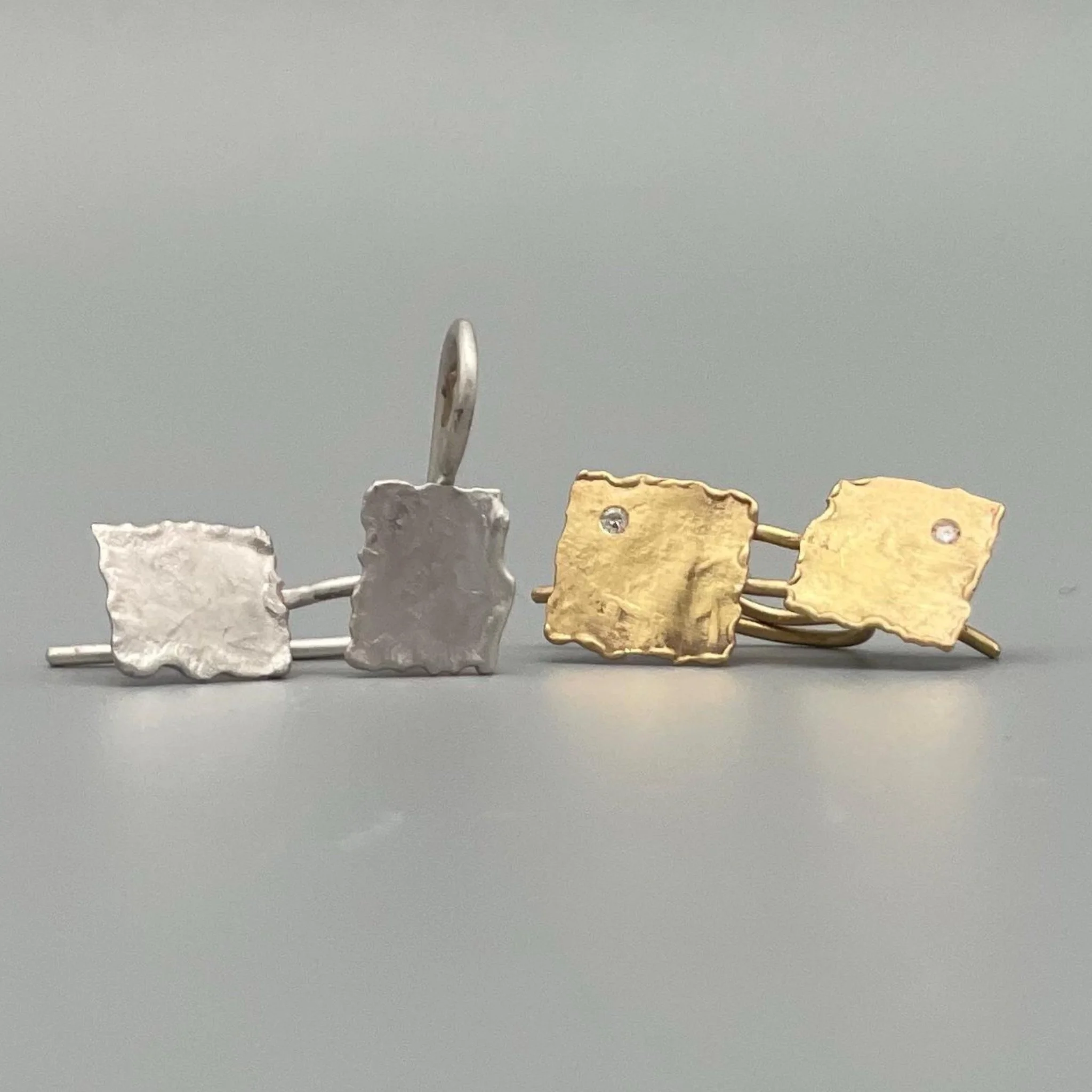 Crepundia Gioielli – .Raw Geometry
Orecchini d’argento e oro con design squadrato e superficie irregolare, caratterizzati da linee pure e lavorazione artigianale.