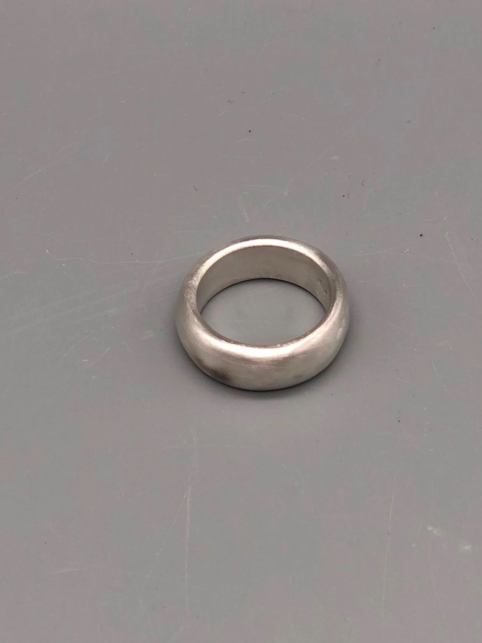 Anello Esse in argento opaco, gioiello contemporaneo dal profilo morbido e dalla fascia ampia. Esse ring in matte silver, contemporary jewellery with a soft profile and a wide band.