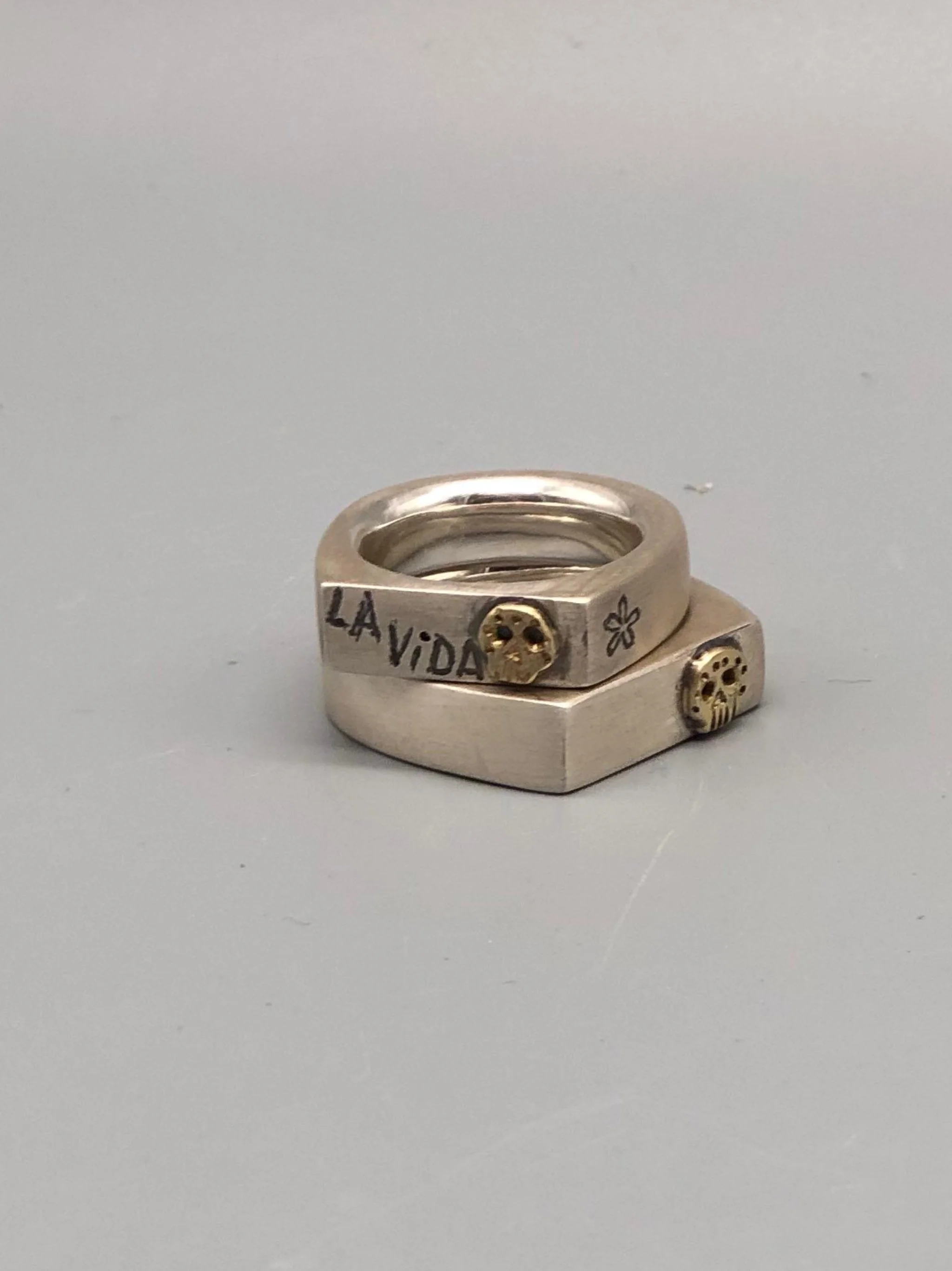 Sonja Markhoff Viva la Vida rings in matte sterling silver with 14 kt gold Calavera detail, contemporary jewelry Crepundia Gioielli Bologna