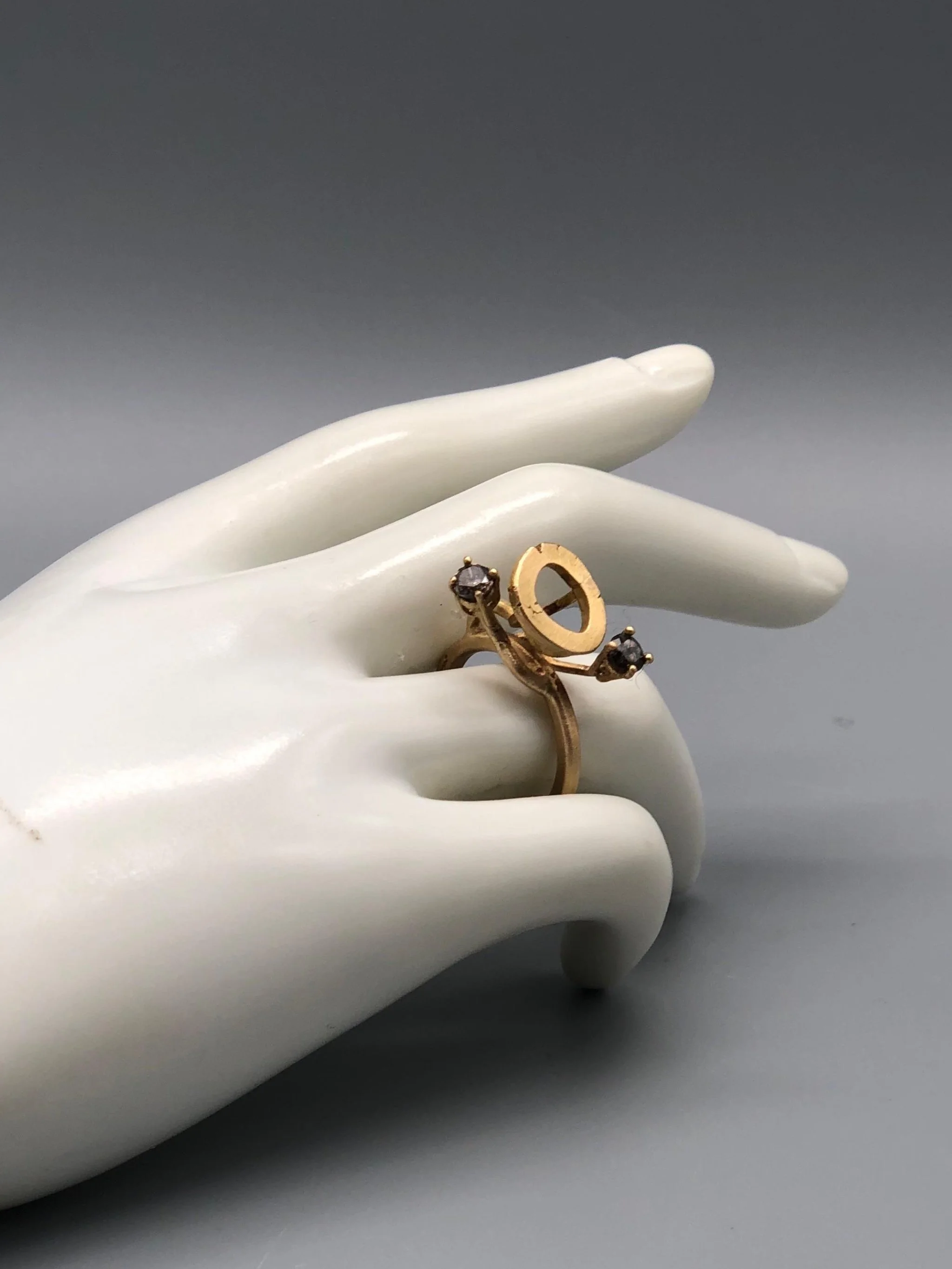 Anello fiore in oro giallo opaco con diamanti grigi indossato sulla mano Marco Mangàni gioiello contemporaneo