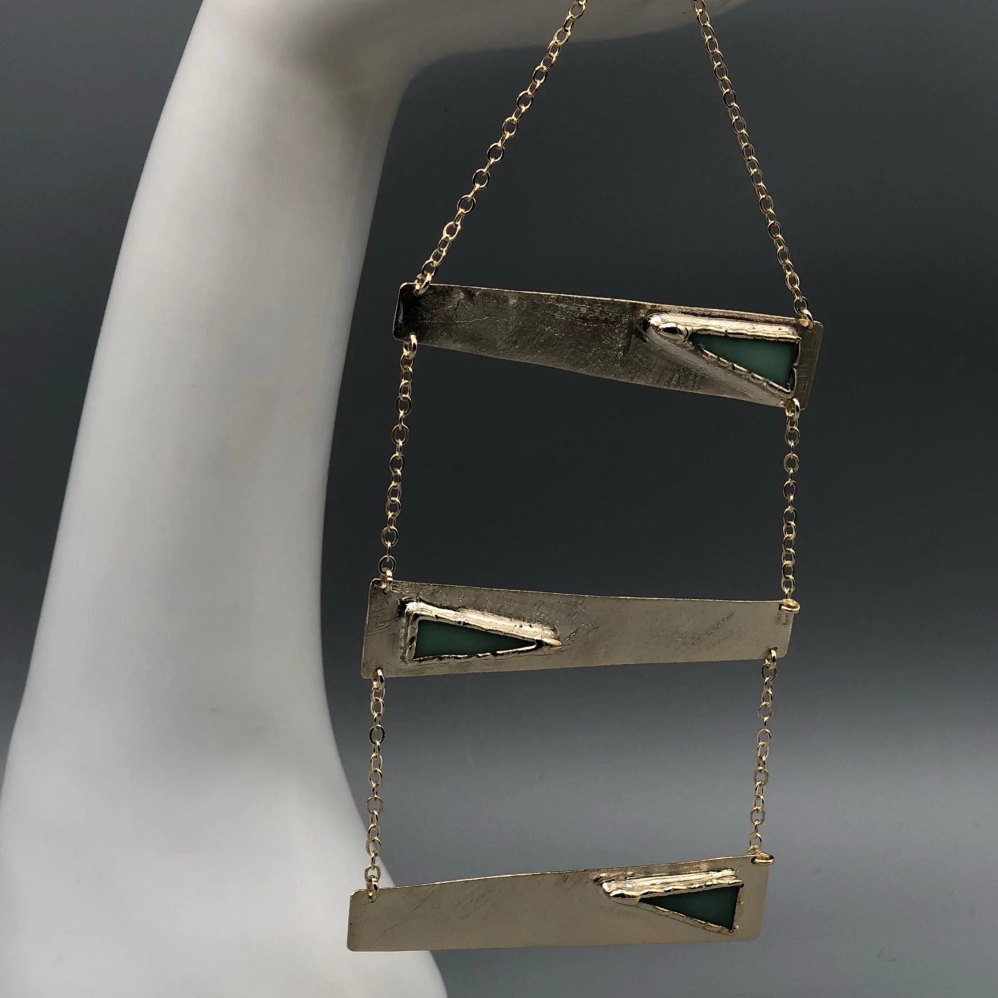 Anni Luce necklace in gold-toned metal with green glass elements, contemporary jewelry Crepundia Gioielli Bologna
Collana Anni Luce in metallo dorato con elementi in vetro verde, gioielli contemporanei Crepundia Gioielli Bologna
