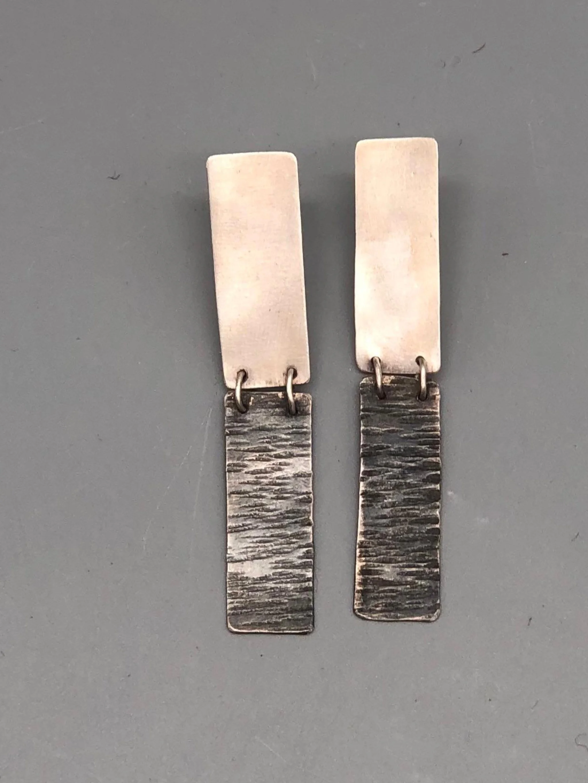 Dual earrings in matte silver and oxidized silver, Crepundia Gioielli Bologna.