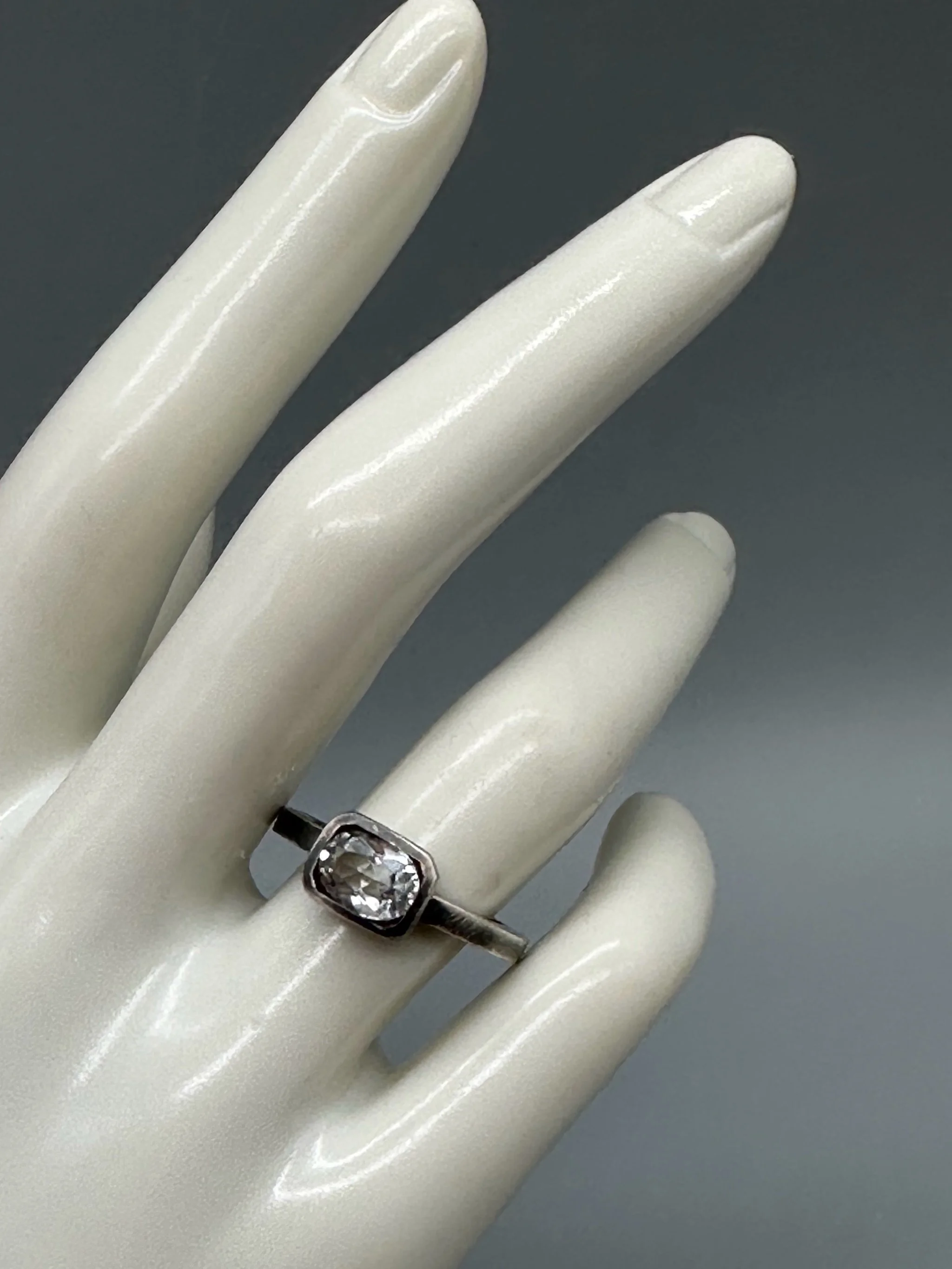 Anello White in Black in argento brunito con topazio bianco sfaccettato e castone geometrico. White in Black ring in oxidized sterling silver with faceted white topaz and geometric setting.