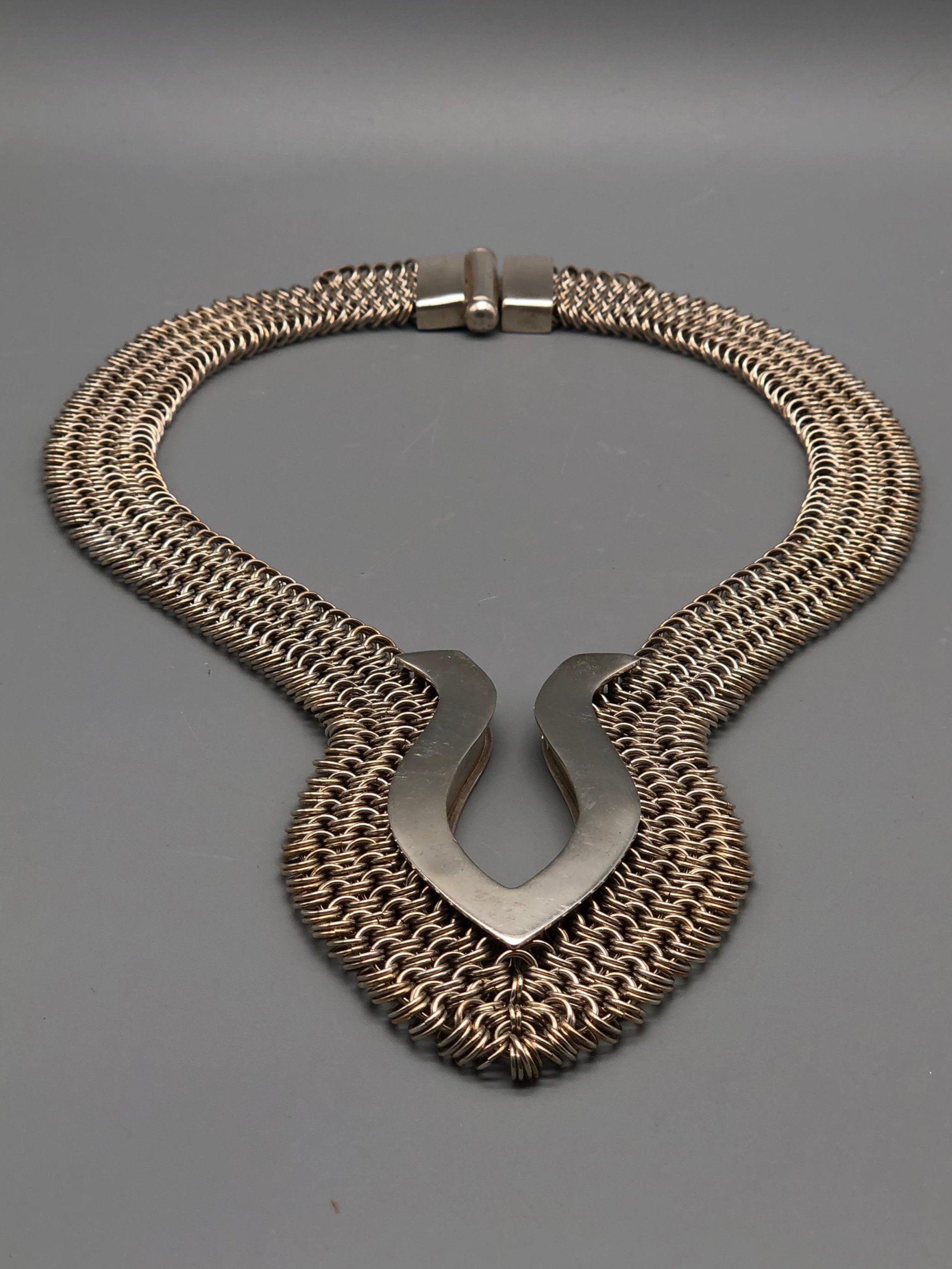Piscis necklace by Ariadna Segafredo, crafted in woven metal mesh with a sculptural clasp for Crepundia Gioielli.