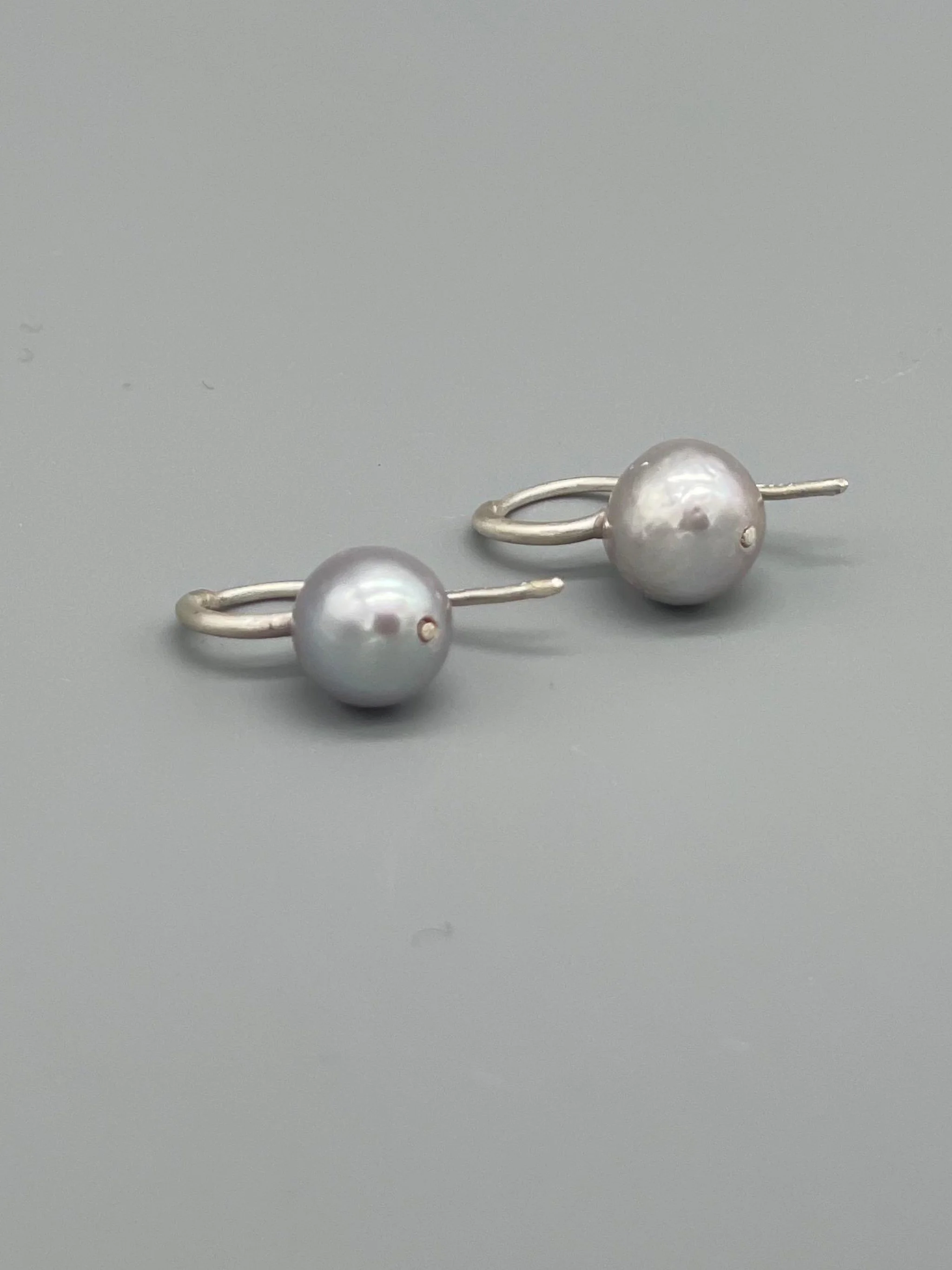 Perle grigie Crepundia in argento opaco, design contemporaneo.