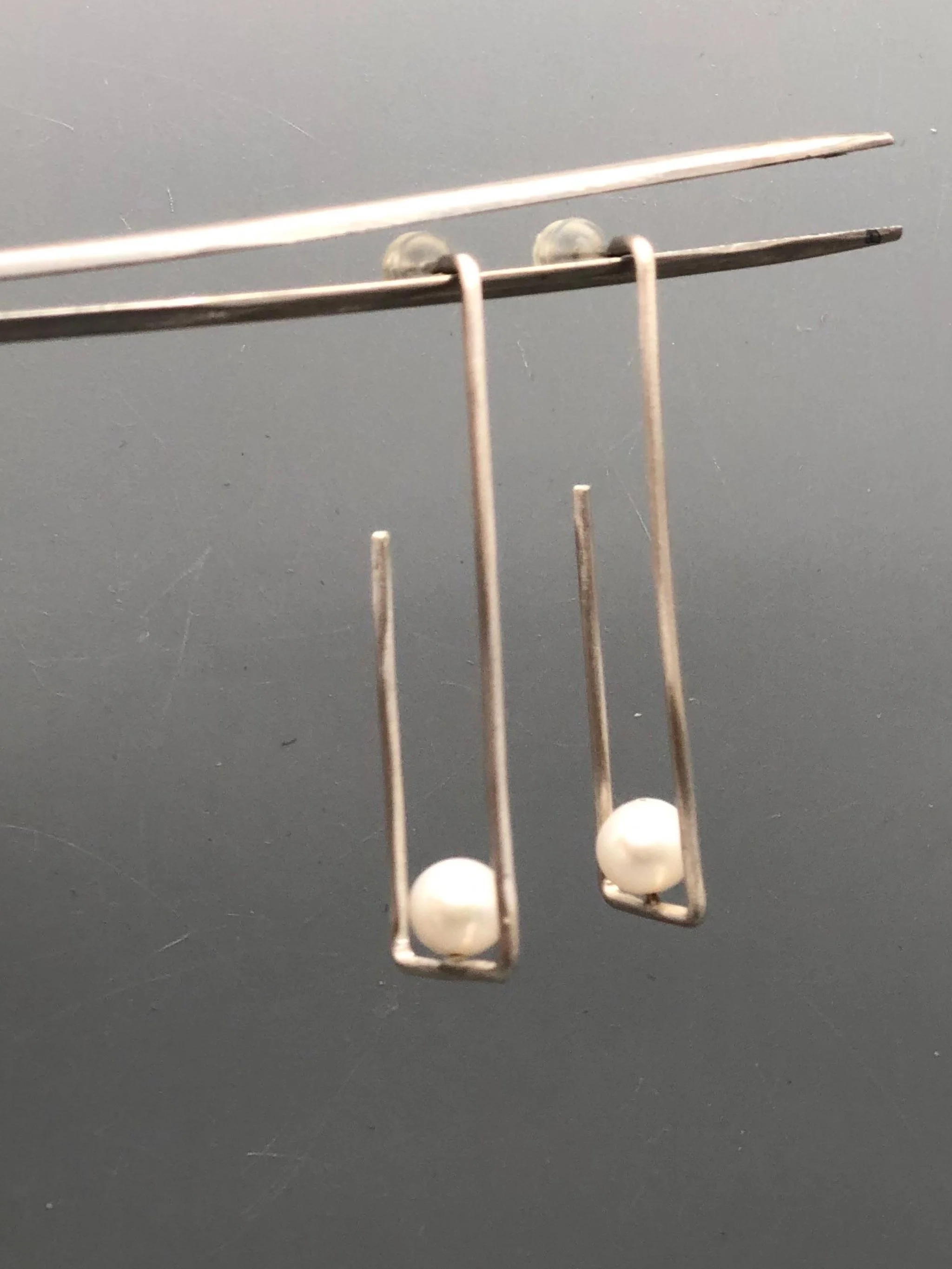 Crepundia Agadir earrings in silver with pearls, featuring an open, asymmetrical geometric design.