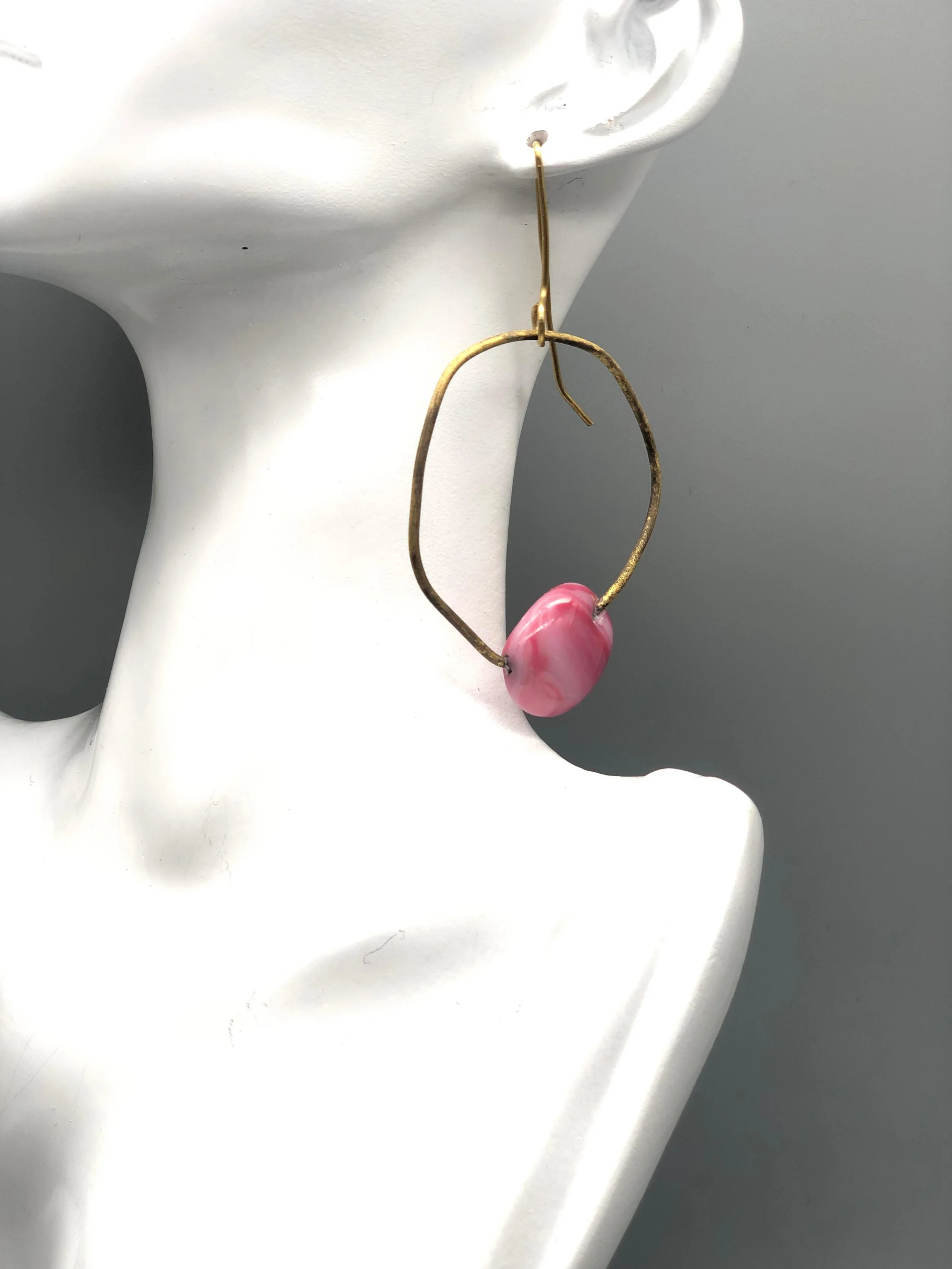 Manumara Arte Design — sculptural earring in fused glass and metal with pink element, available at Crepundia Gioielli Bologna.