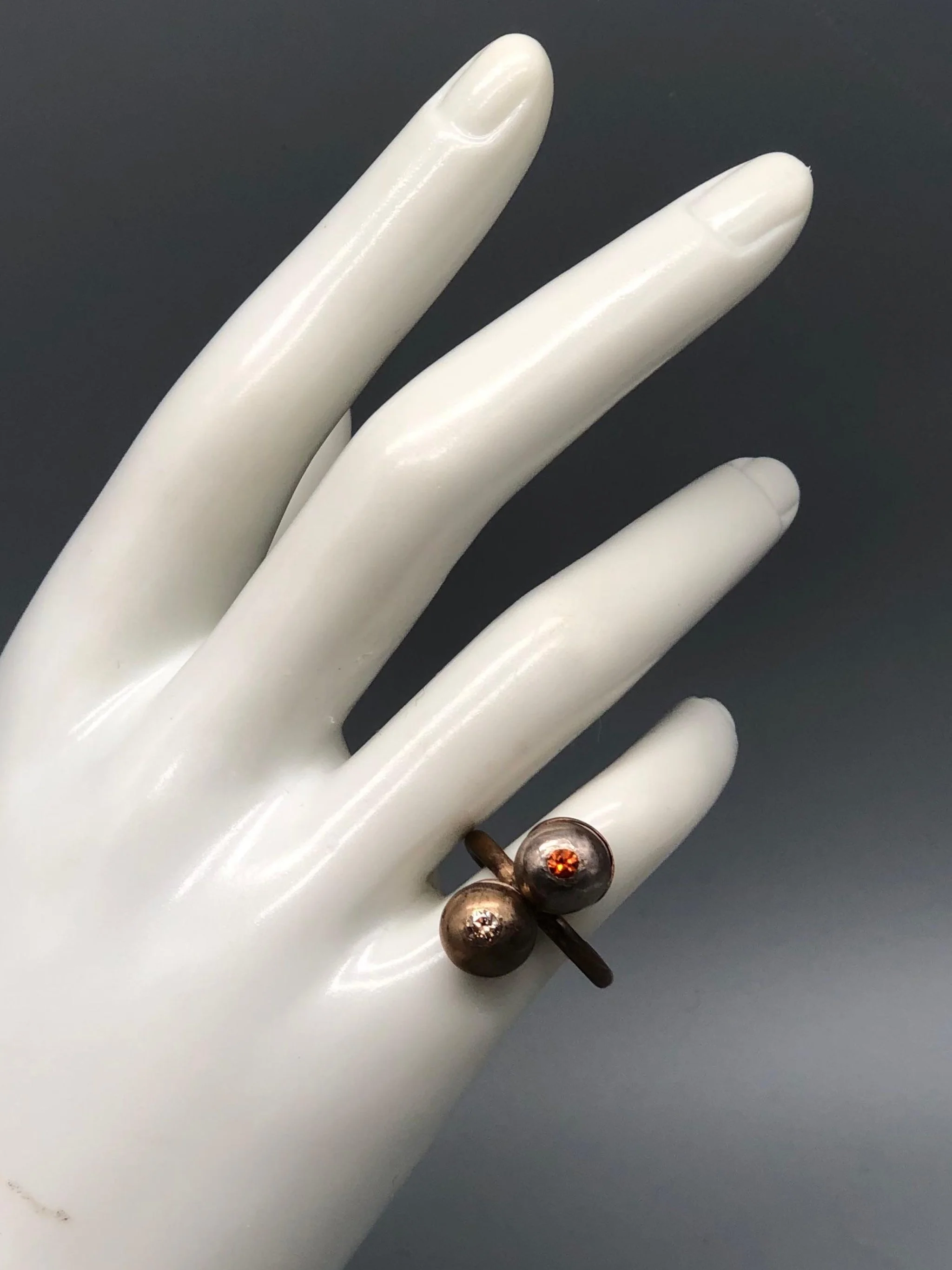 Riccardo Raimondi bronze ring with cognac quartz and spessartite garnet, double sphere design, contemporary jewelry Crepundia Gioielli Bologna