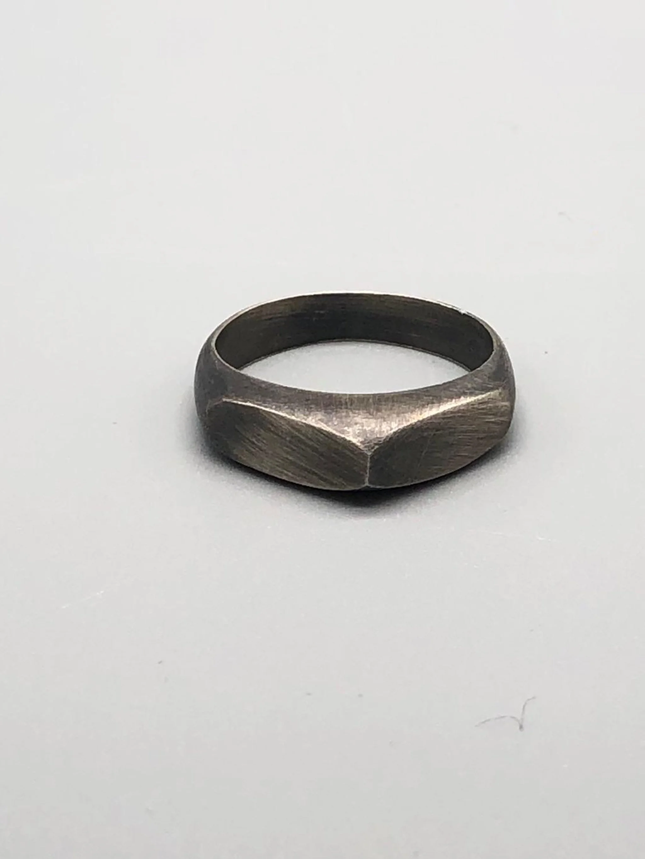 Anello Cuspide Crepundia in argento 925 brunito, con fascia geometrica, superfici sfaccettate e finitura scura satinata\.  *Crepundia Cuspide ring in oxidized sterling silver 925, featuring a geometri