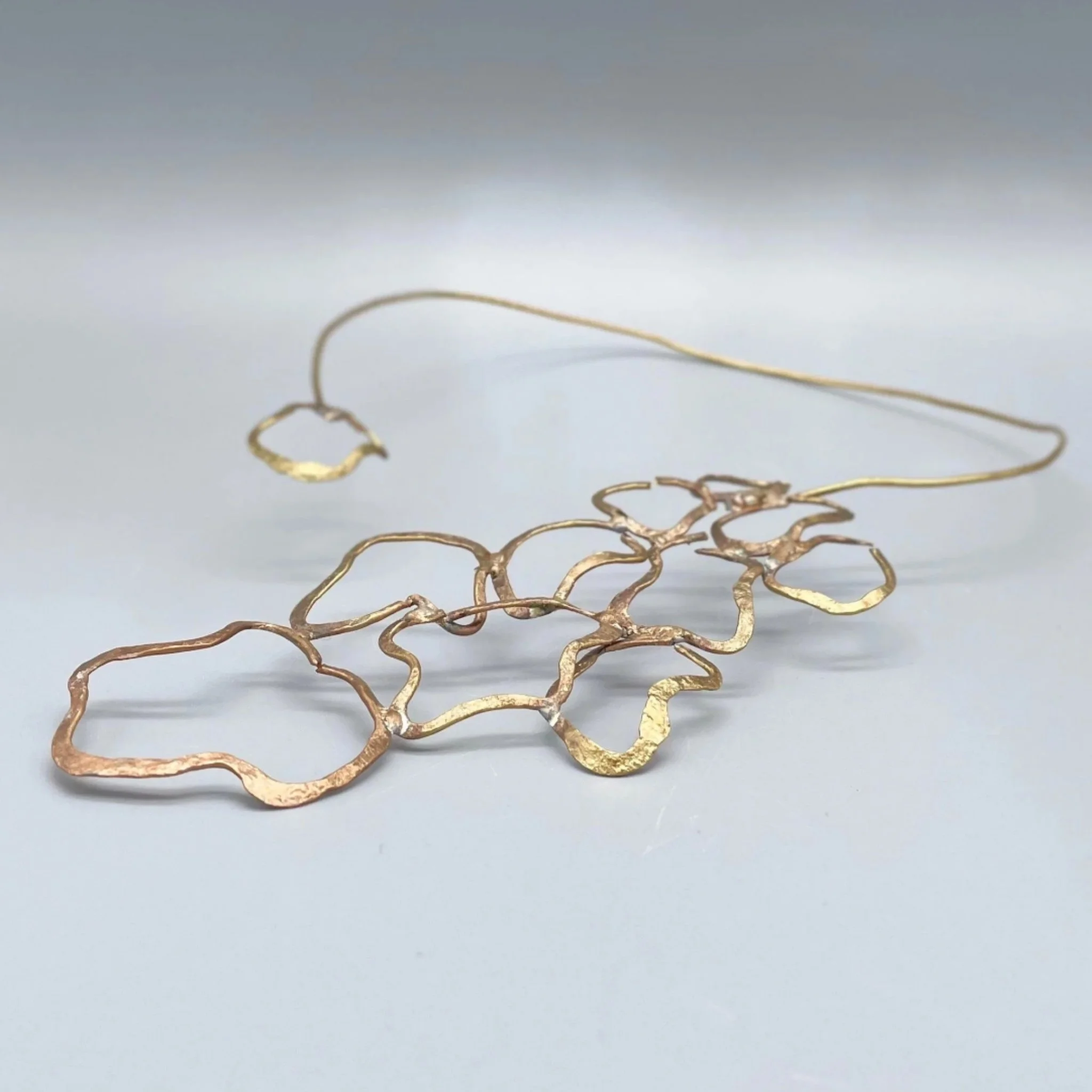 Collana rigida in ottone Claudia Cuzzeri, forma scultorea essenziale modellata attraverso gesto diretto e tensione materica — Crepundia Gioielli, Crepundia Bologna / Rigid brass necklace by Claudia Cuzzeri, essential sculptural form shaped through di