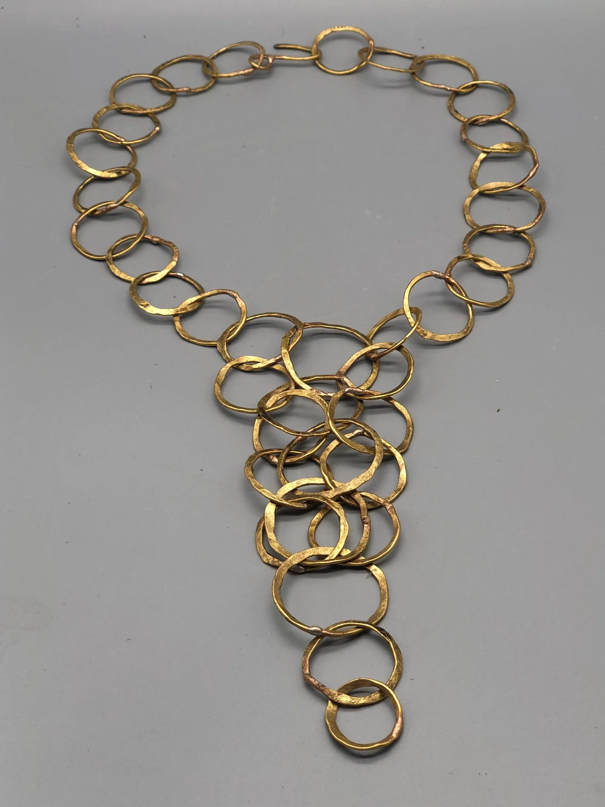 Collana Full Outline di Claudia Cuzzeri in ottone opaco, con maglie irregolari sovrapposte e struttura centrale ampia e articolata.