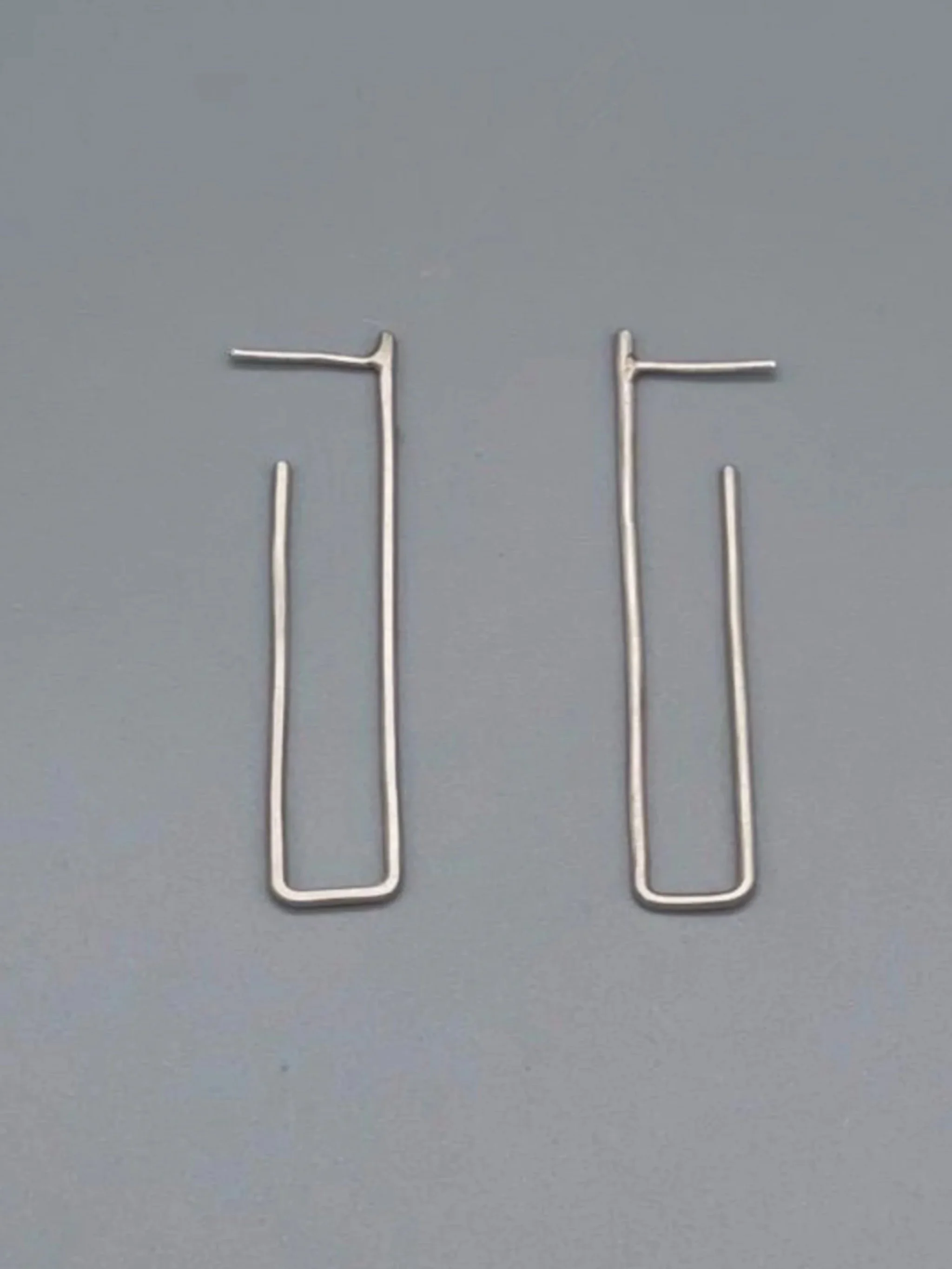 Orecchini .111 Crepundia in argento 925, dalla forma geometrica allungata e minimale.