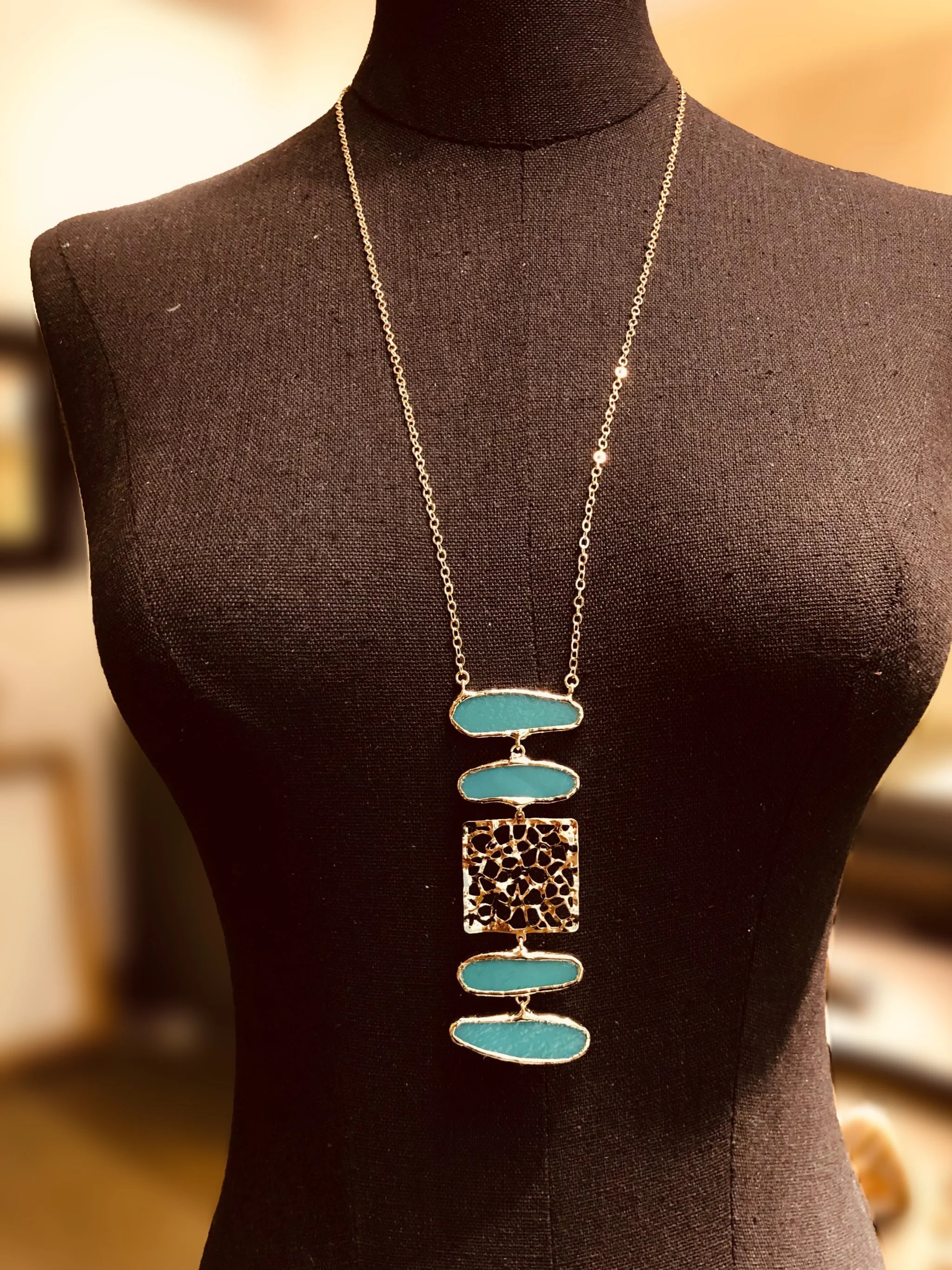 Collana Organica Verde di Anni Luce con elementi verdi e inserto centrale in ottone traforato.