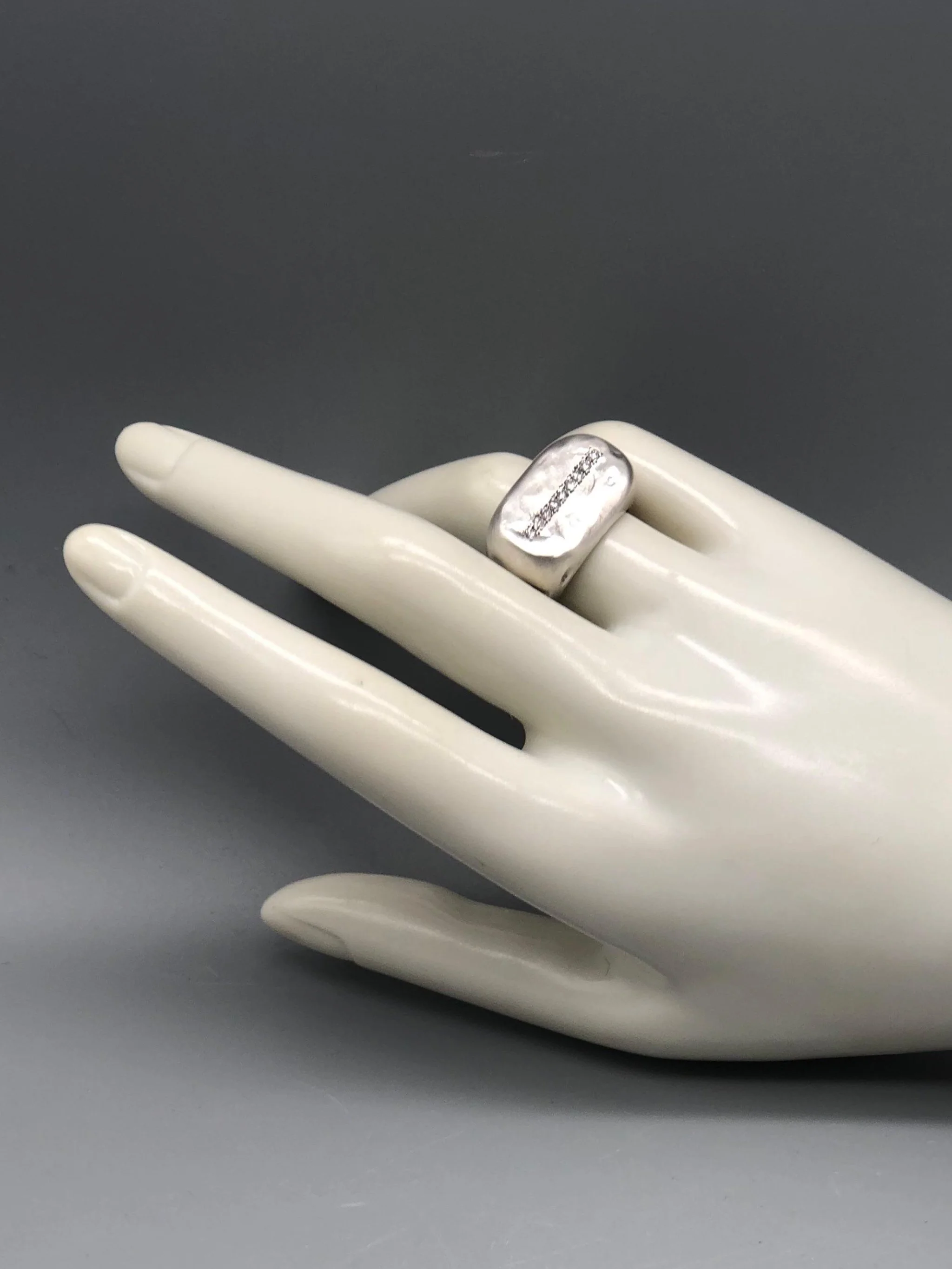 Crepundia Gioielli New Echo ring in matte silver with a line of diamonds.