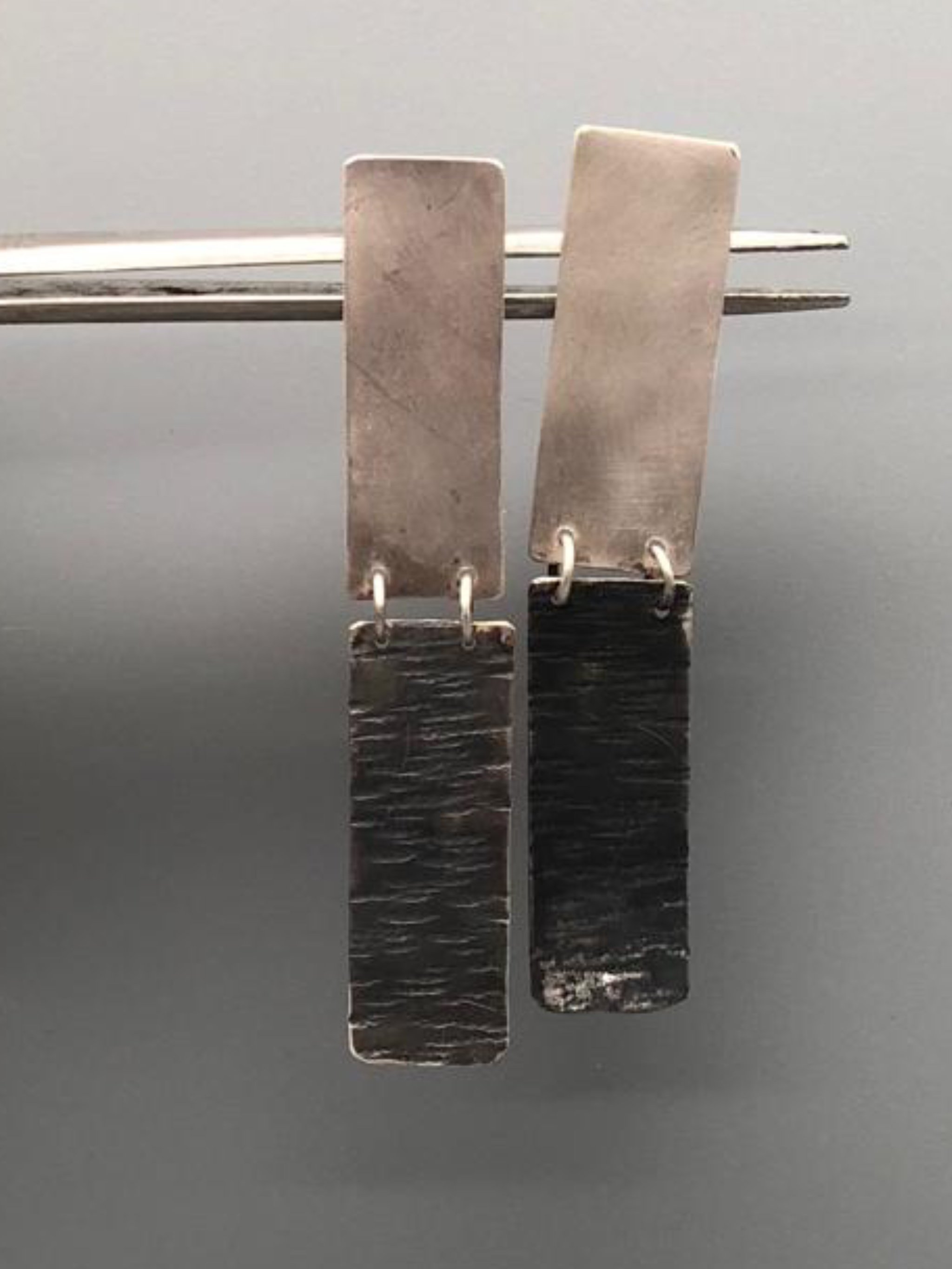 Dual earrings in matte silver and oxidized silver, Crepundia Gioielli Bologna.