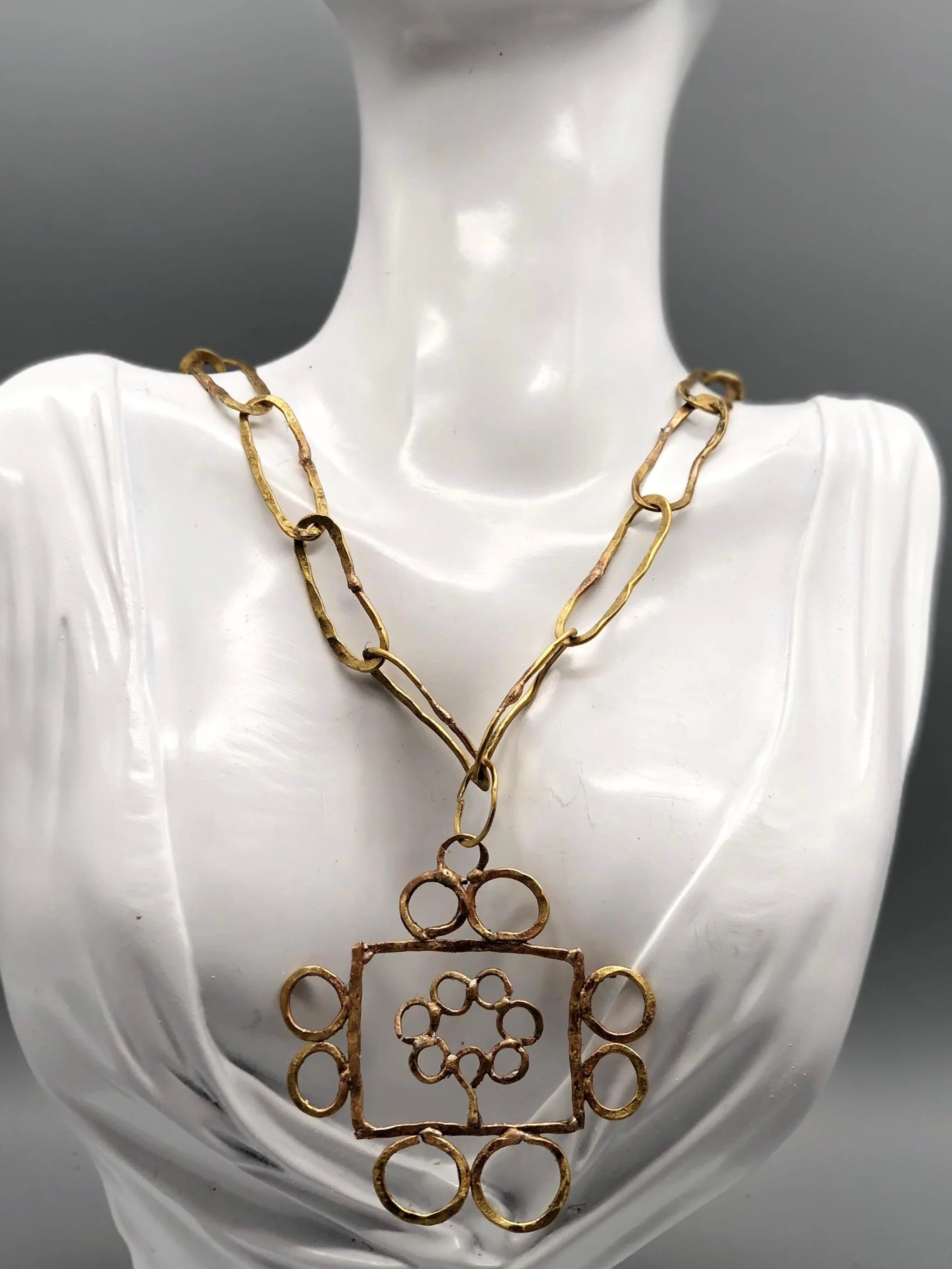Collana Tree Frame di Claudia Cuzzeri in ottone opaco con maglie irregolari e pendente geometrico.
