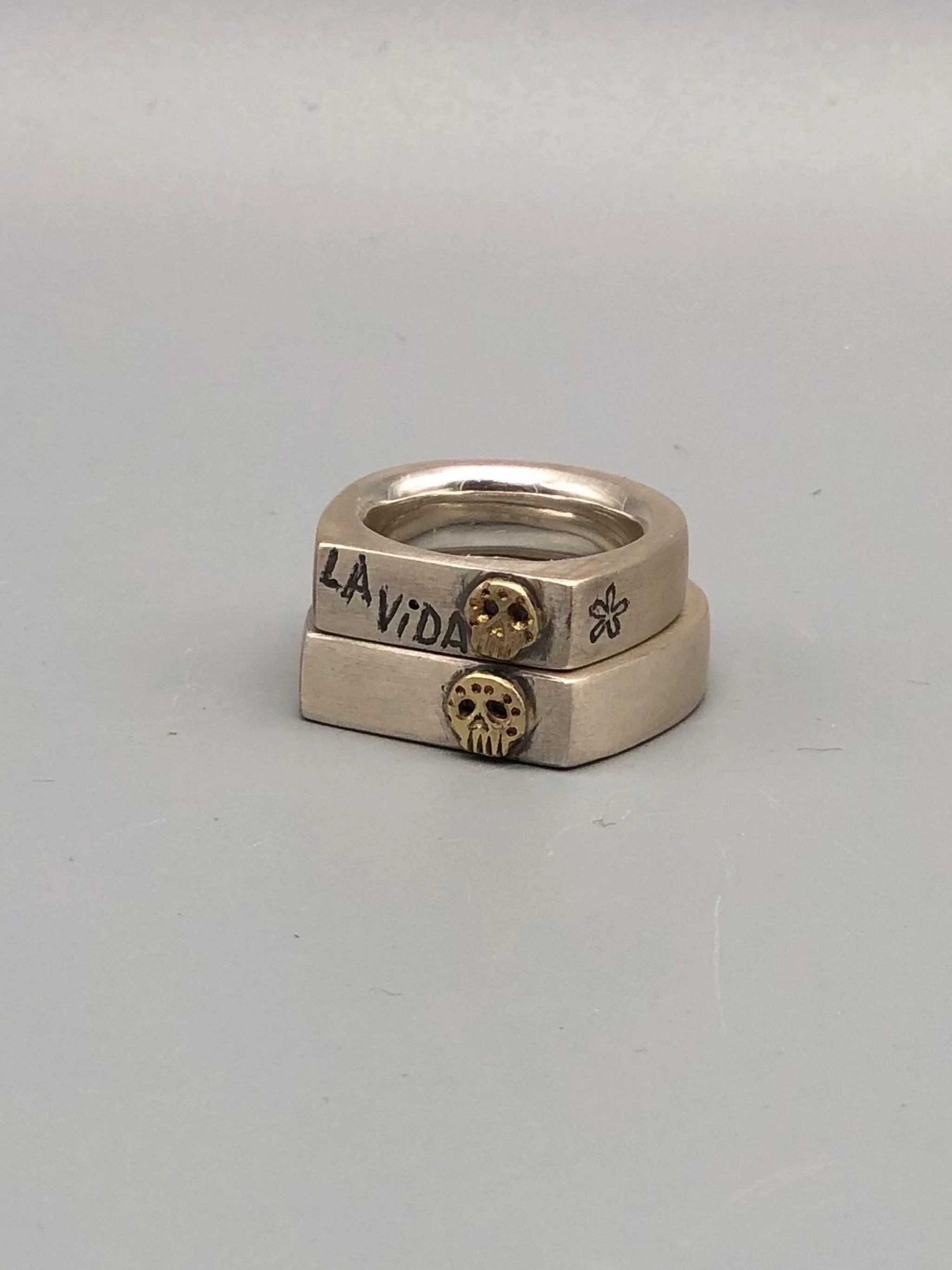 Sonja Markhoff Viva la Vida rings in matte sterling silver with 14 kt gold Calavera detail, contemporary jewelry Crepundia Gioielli Bologna